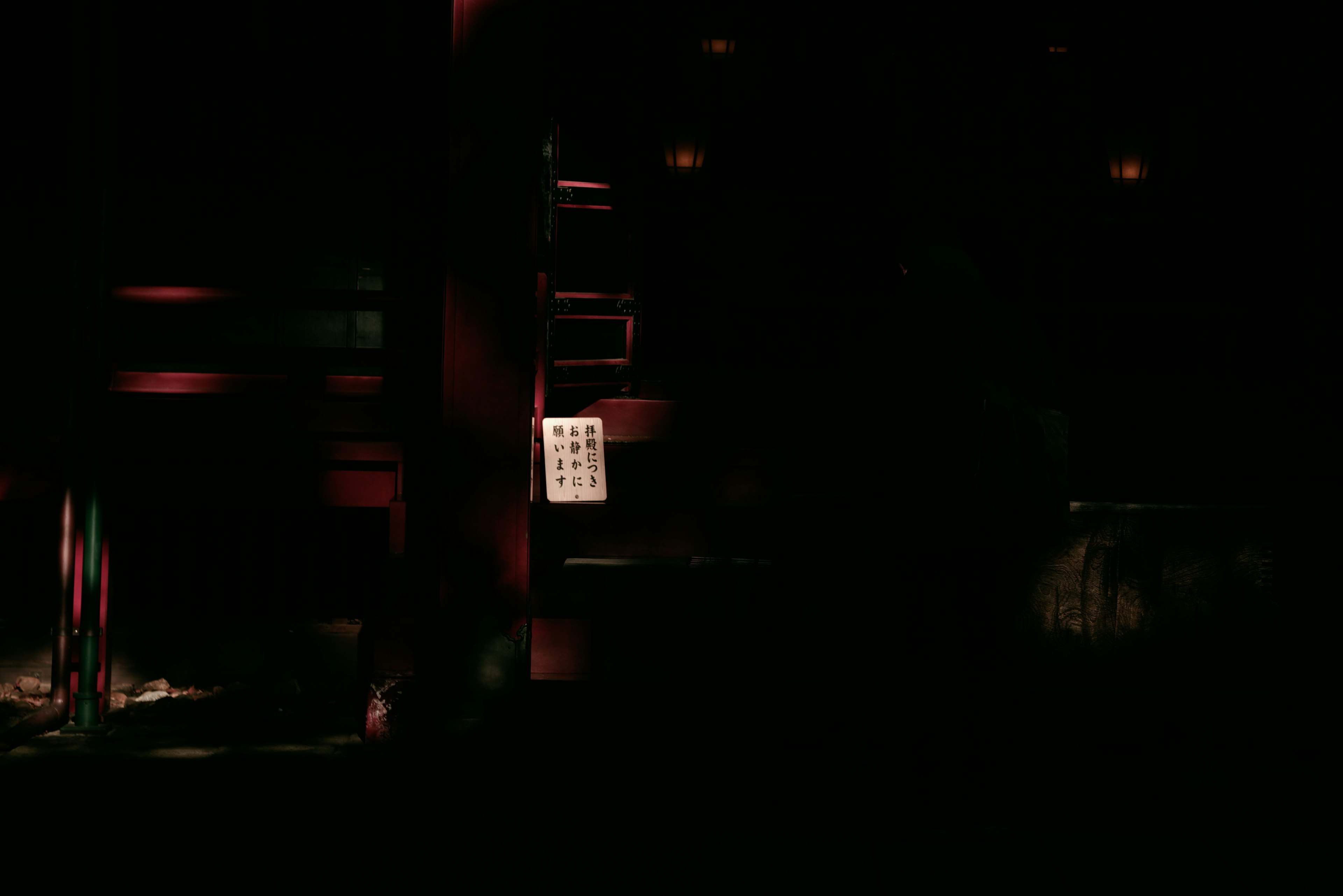 Dimly lit interior with red lighting featuring visible sheet music