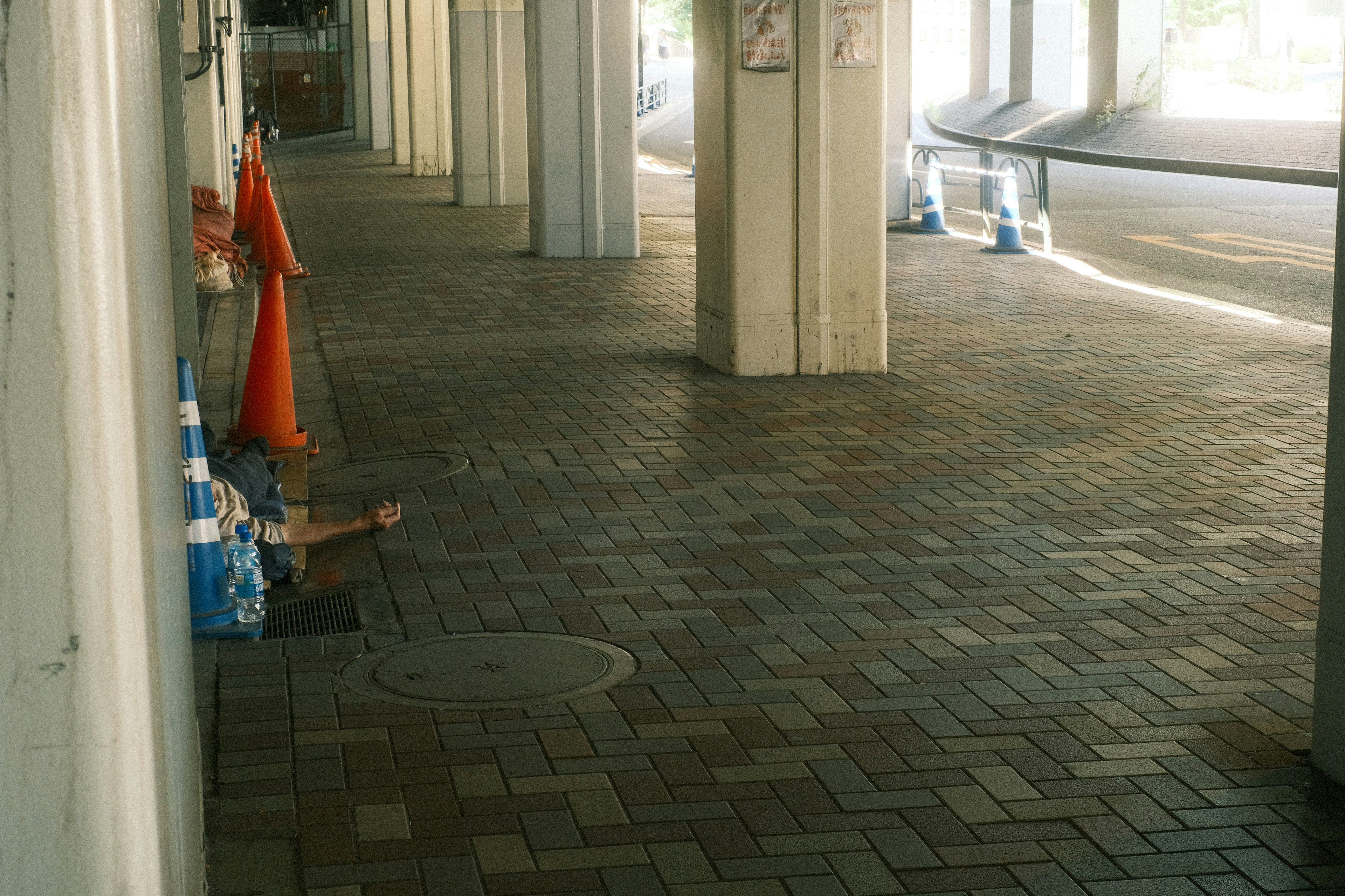 Wide space under a walkway with orange traffic cones lined up