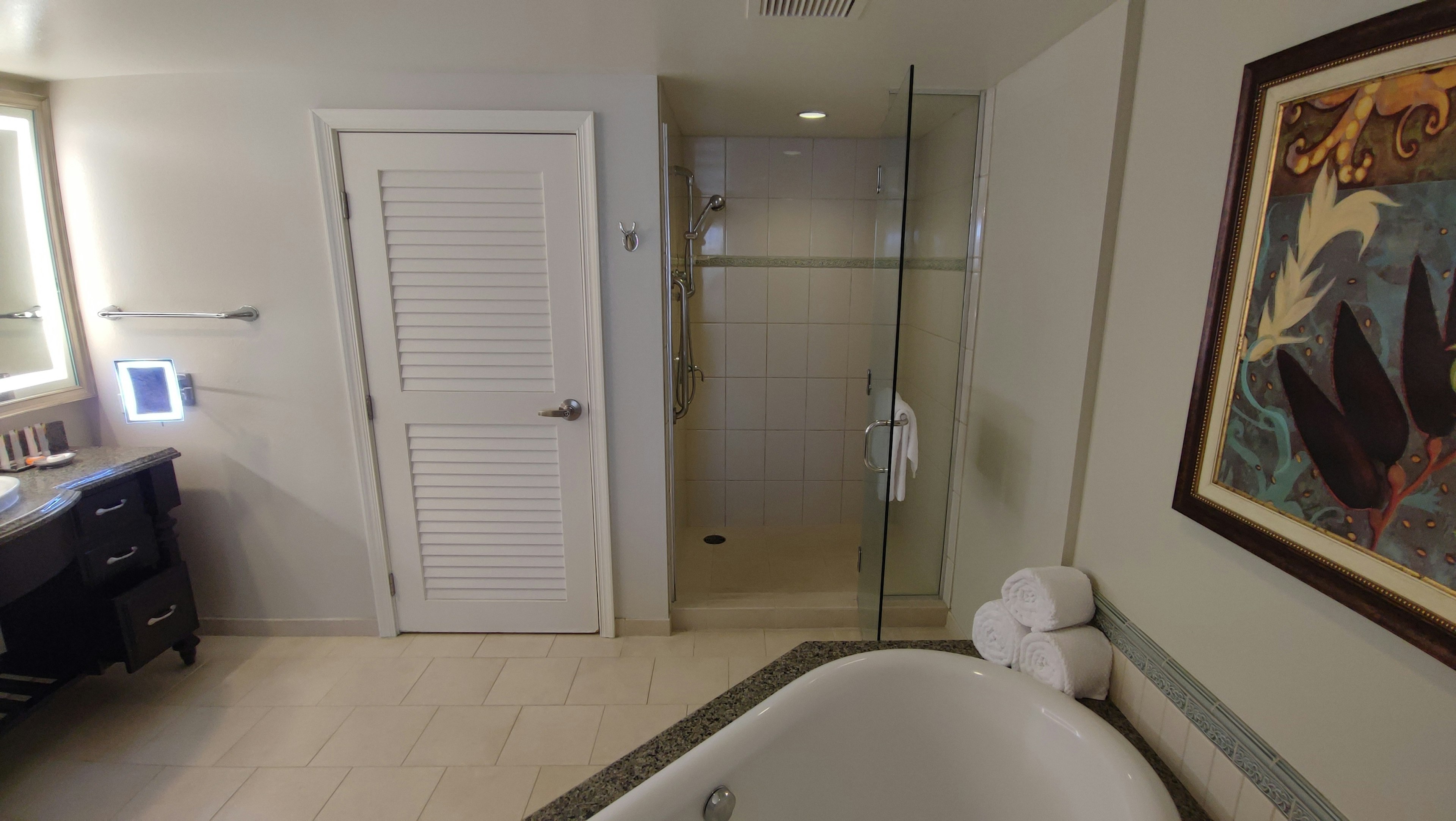 Intérieur de salle de bain lumineux avec douche, lavabo, baignoire et œuvre d'art