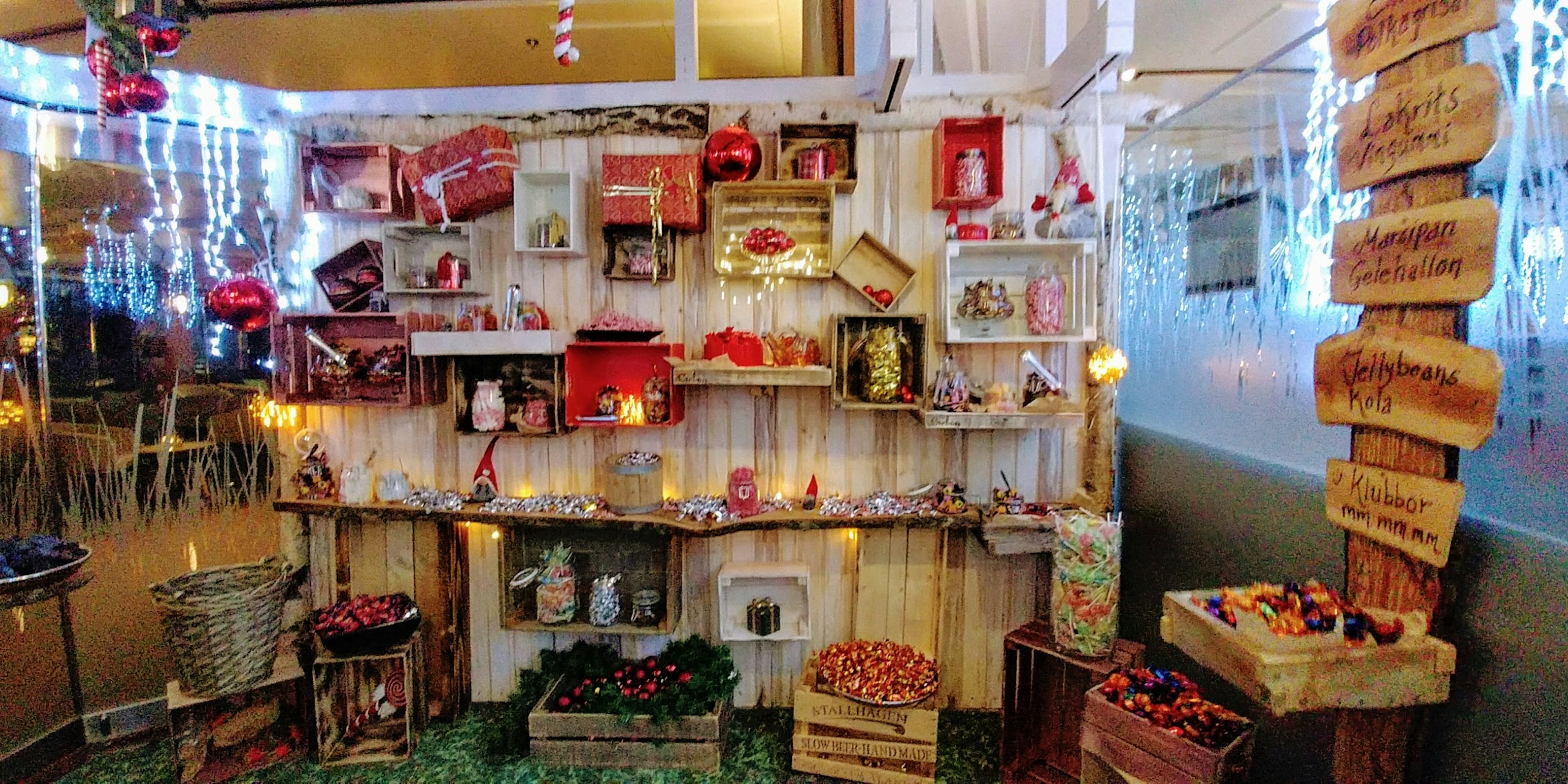 Christmas-themed decorations displayed on a wooden shelf with lights