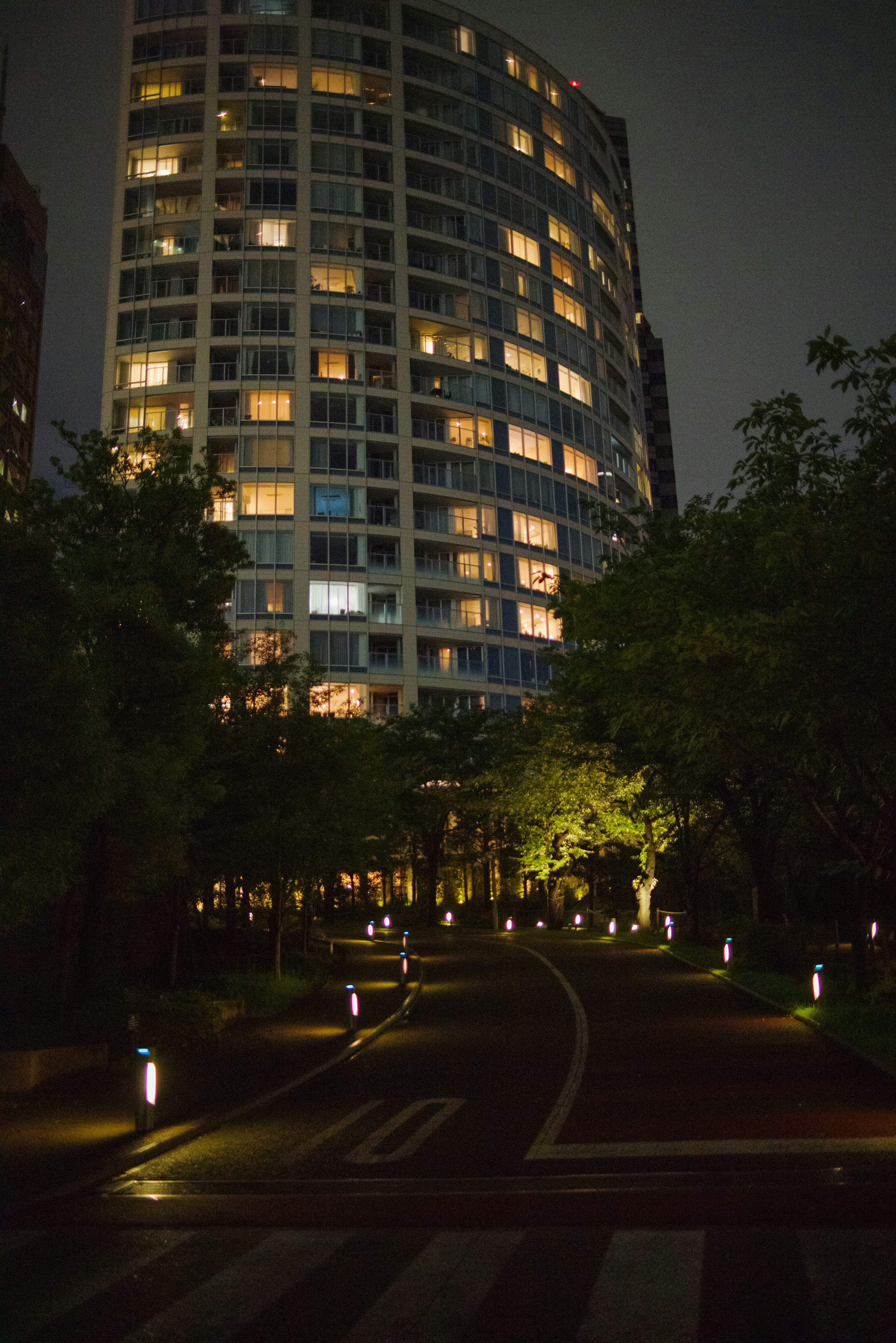 Vue nocturne d'une rue de la ville avec un bâtiment en hauteur illuminé