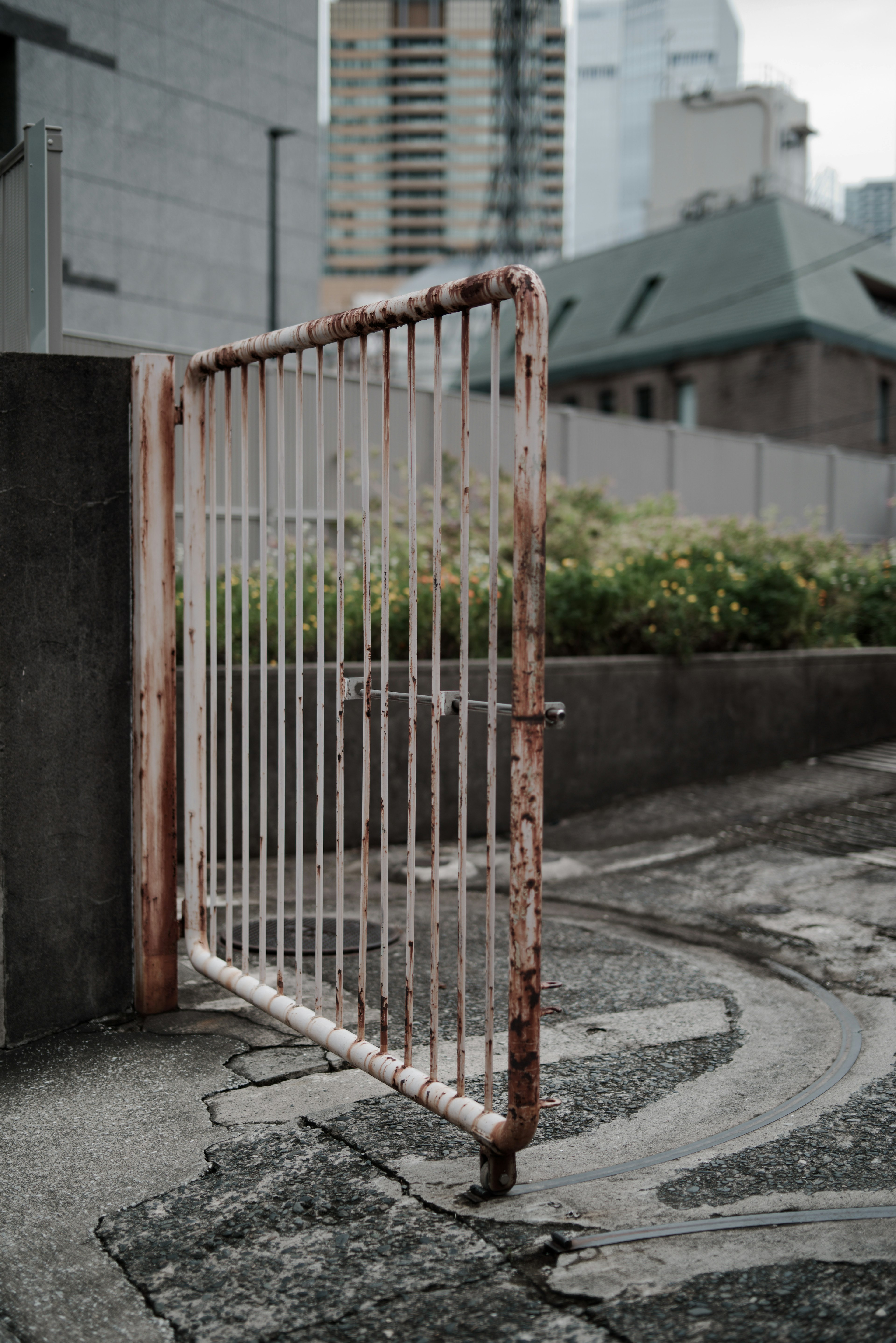 錆びた白いゲートが都市の背景に立っている