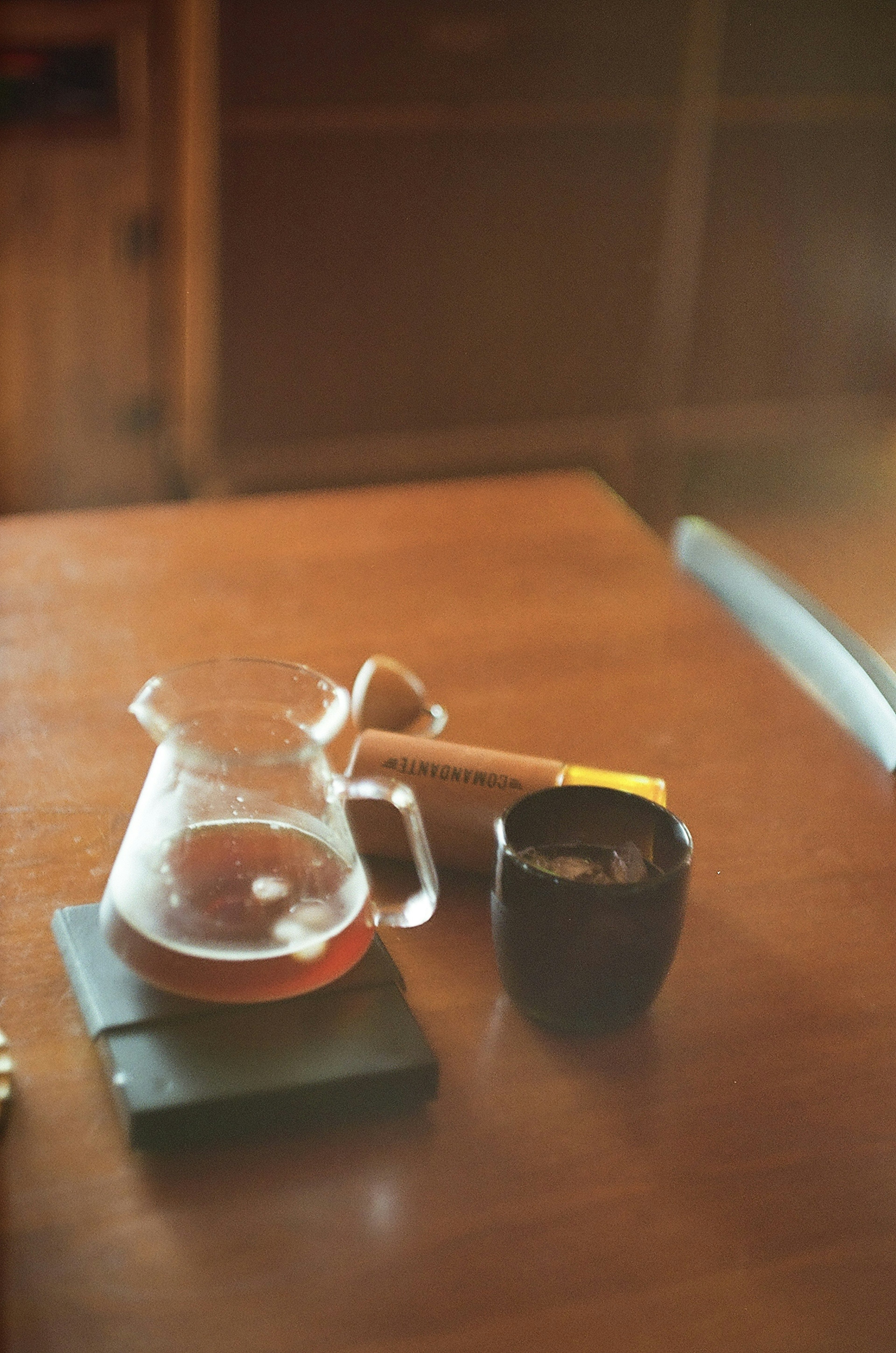 Servidor de café y taza colocados sobre una mesa de madera