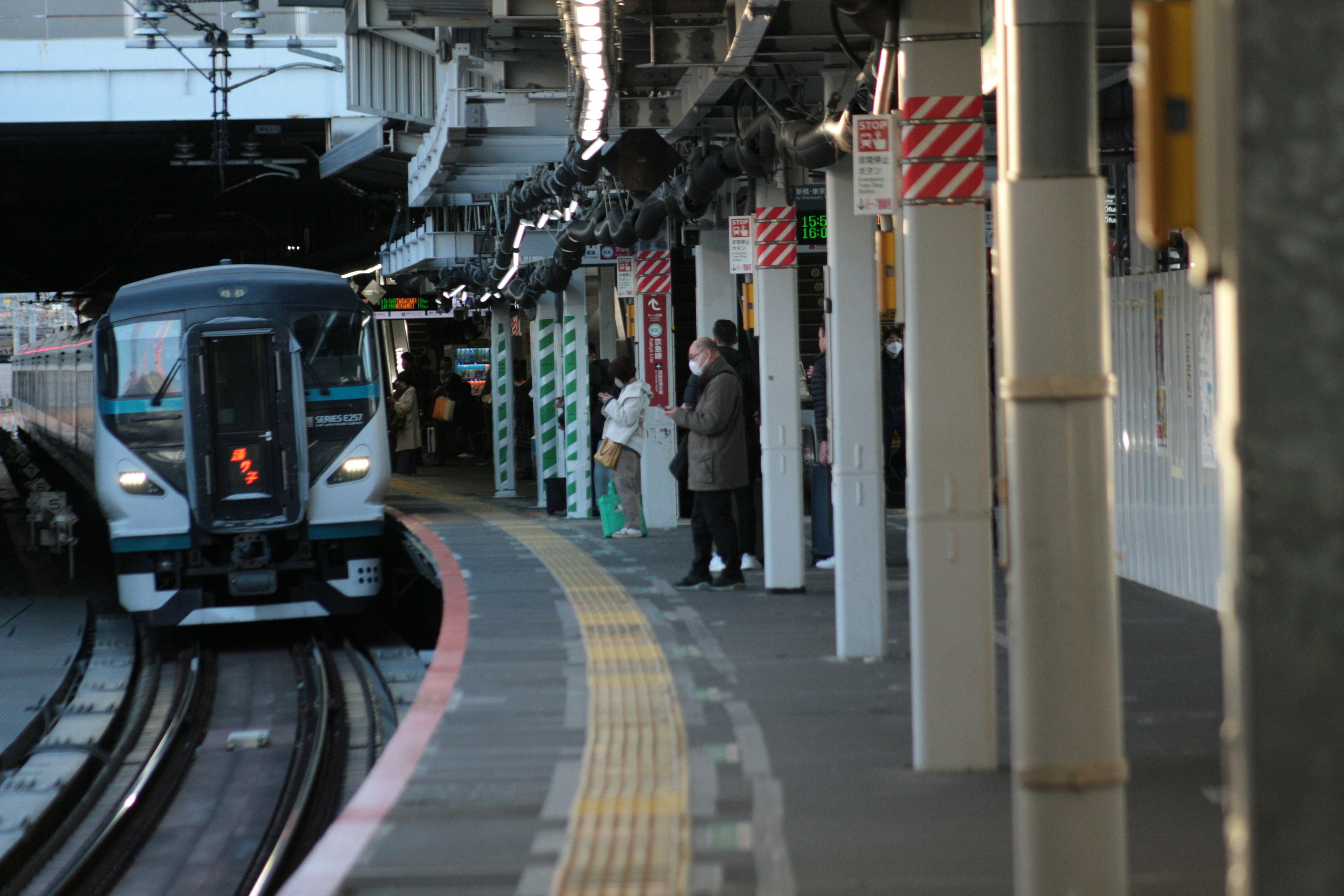 Train approaching the platform with waiting passengers