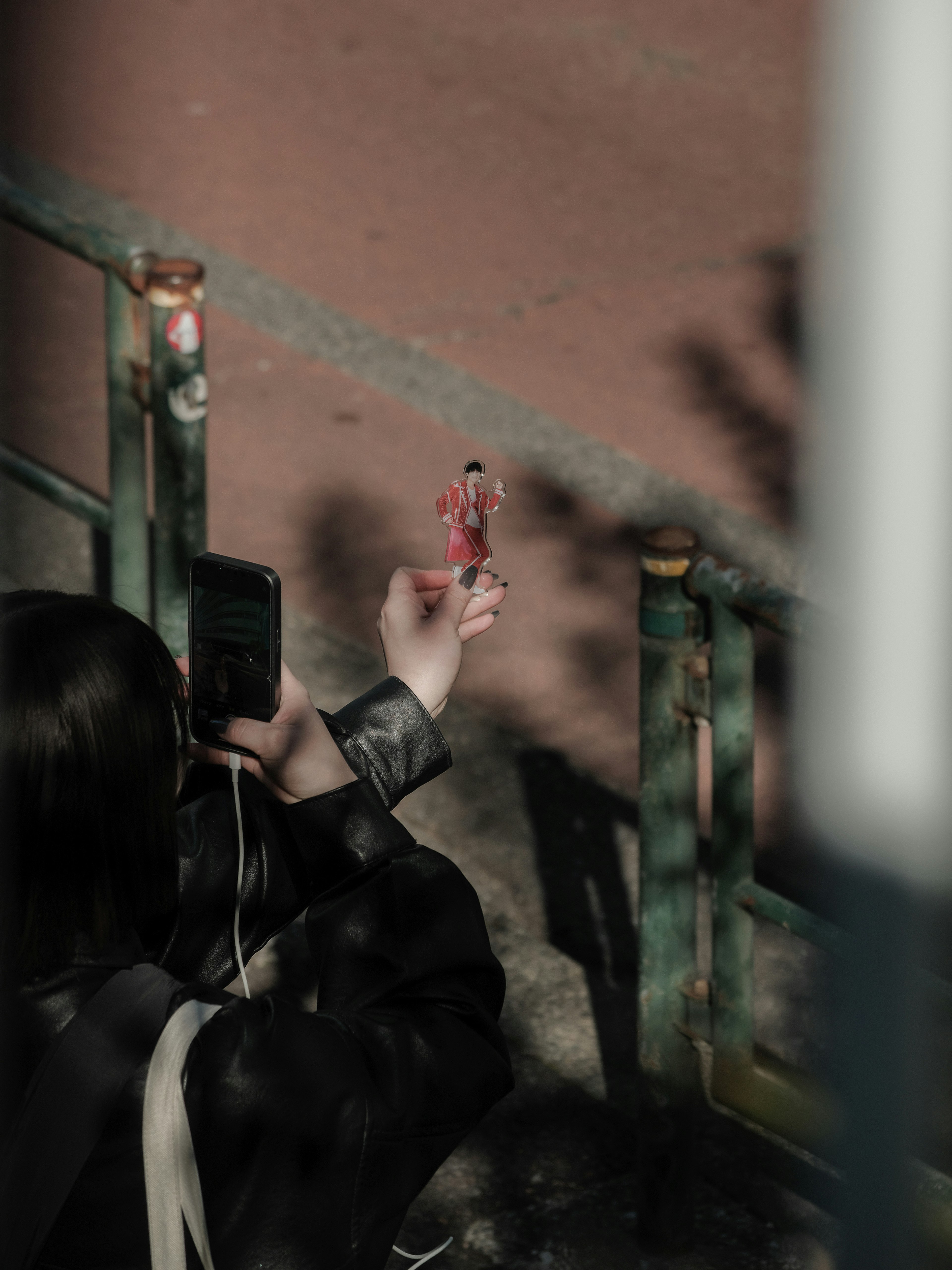 A woman taking a photo of a doll in a park