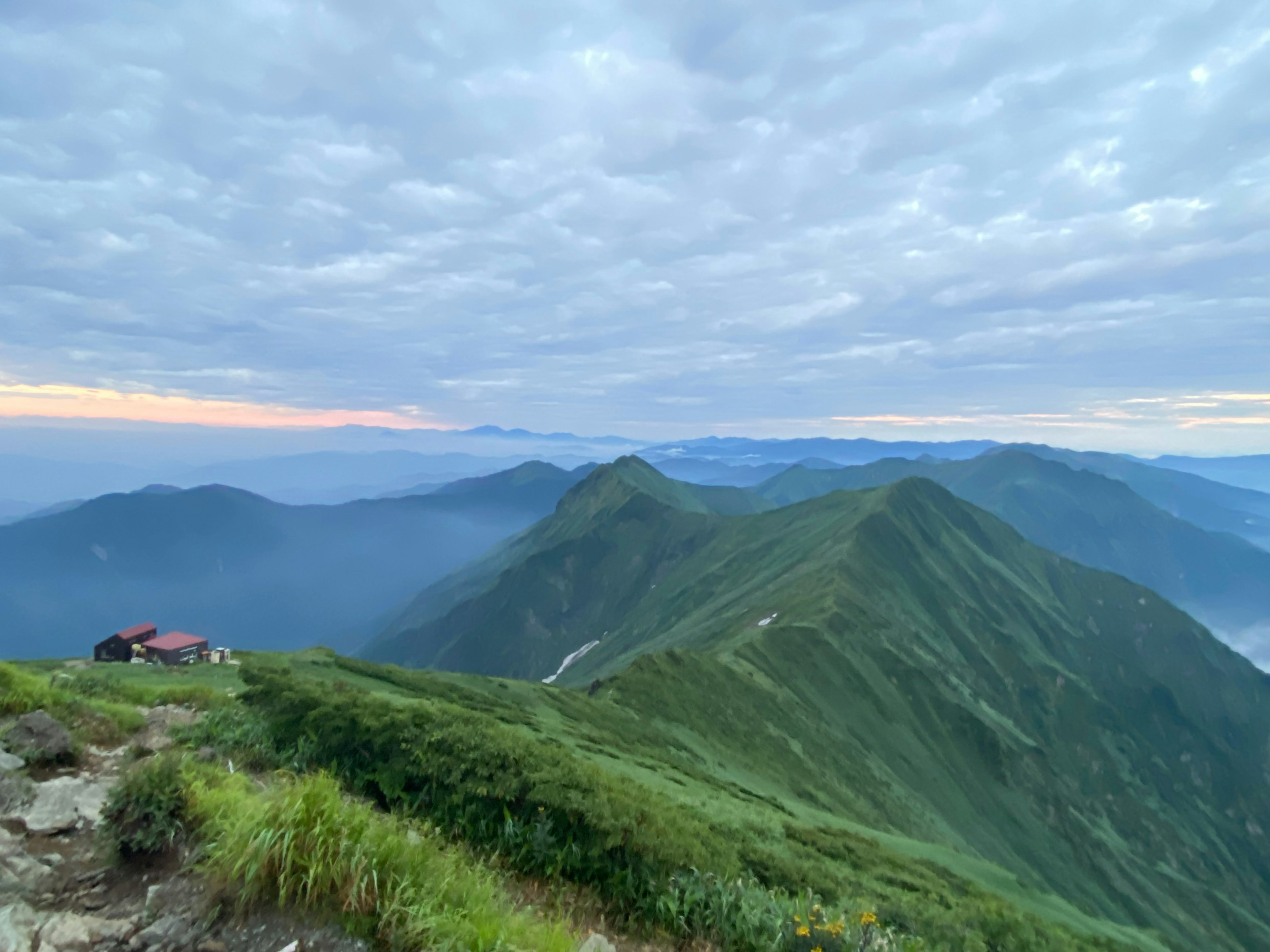 山々と雲の広がる風景 明るい朝の空と緑の丘