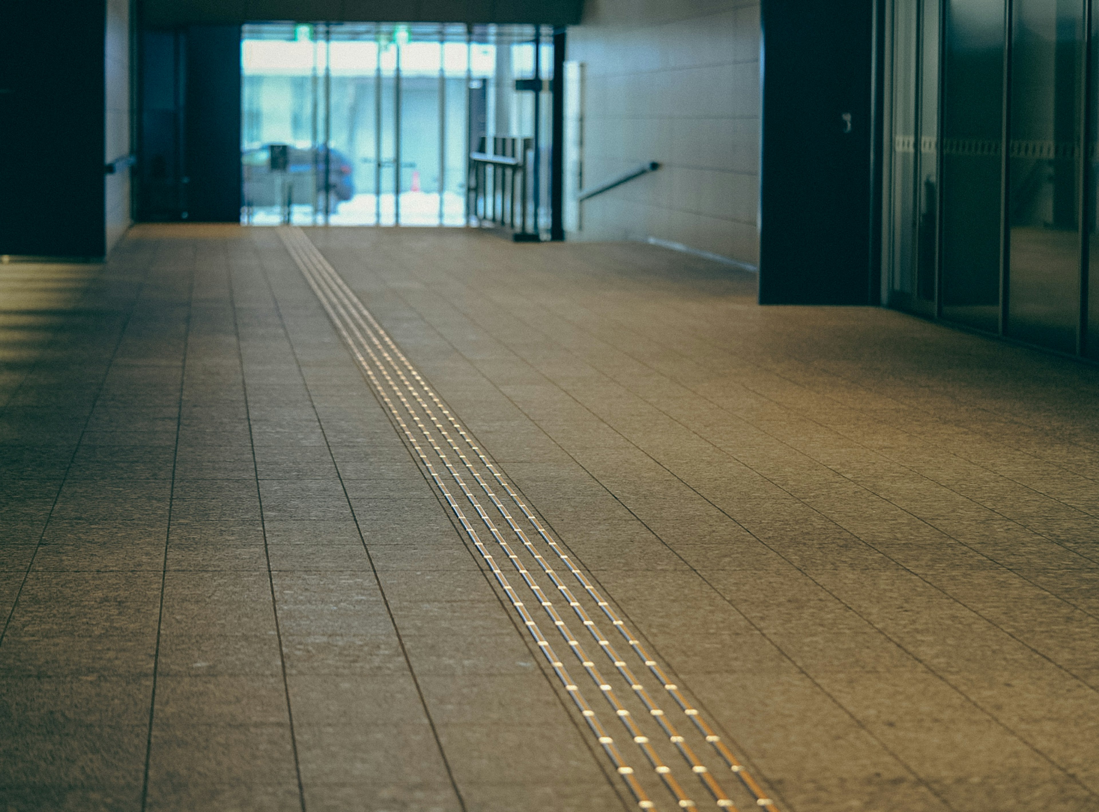 Interno moderno di un edificio con pavimento piastrellato liscio e linee guida illuminate