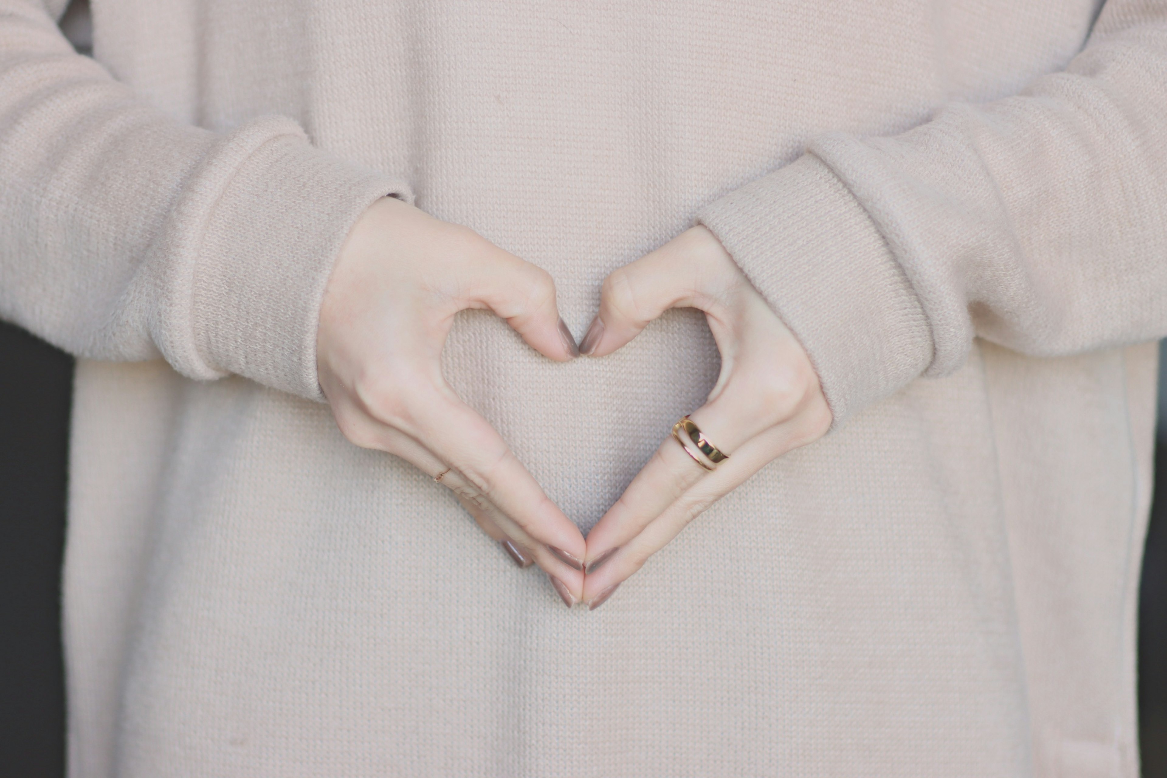 Primo piano delle mani di una donna che formano un cuore