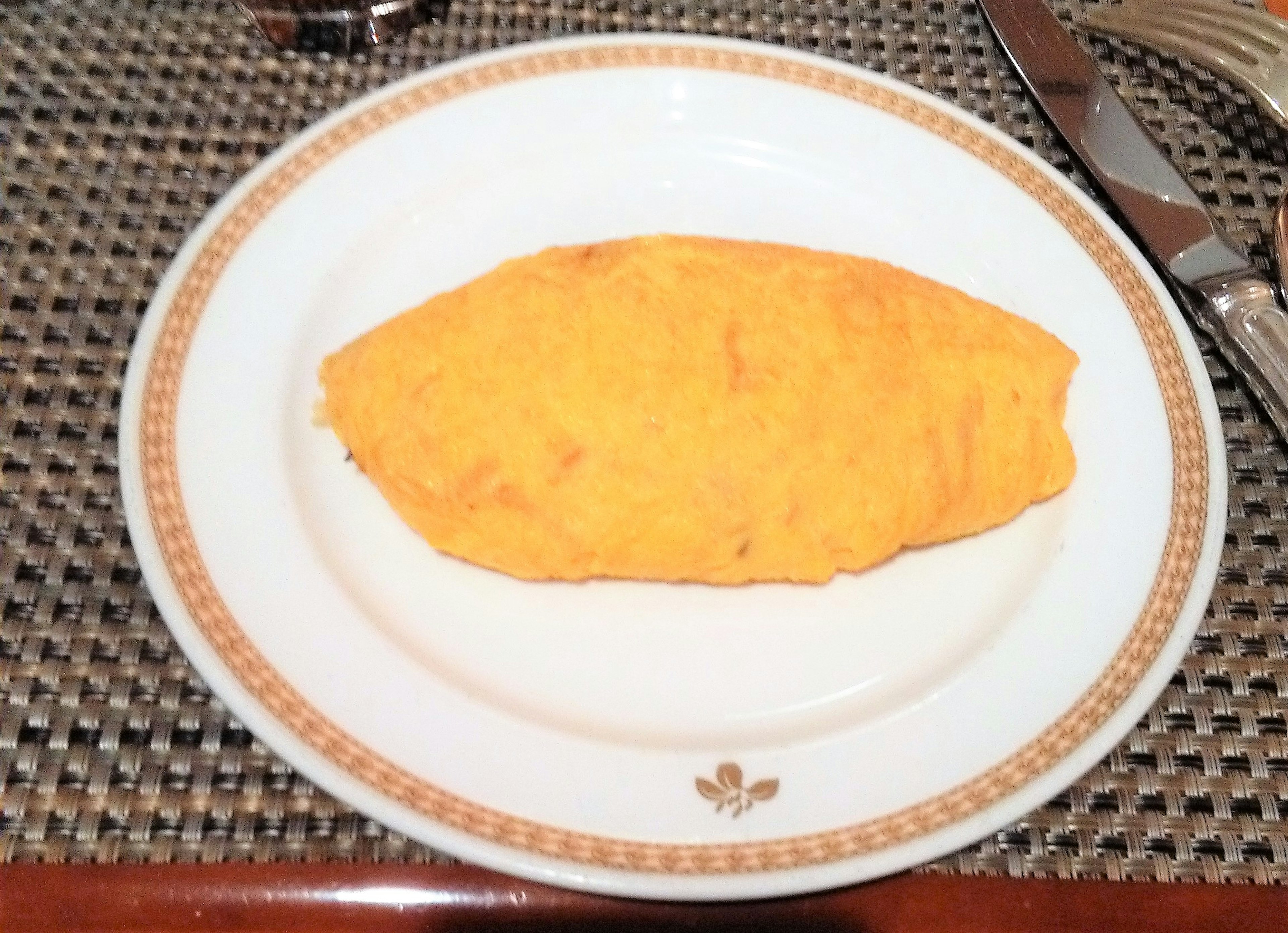 Une photo d'une omelette sur une assiette une omelette jaune repose sur une assiette ronde