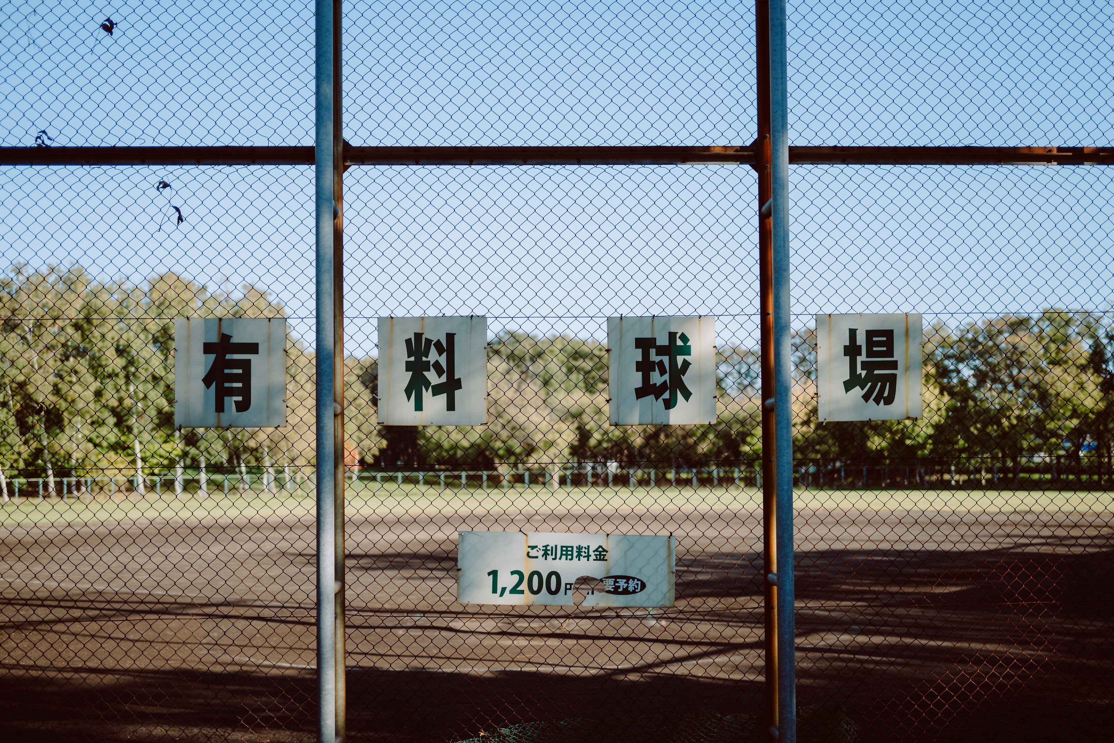 Panneaux d'un terrain de baseball visibles à travers une clôture