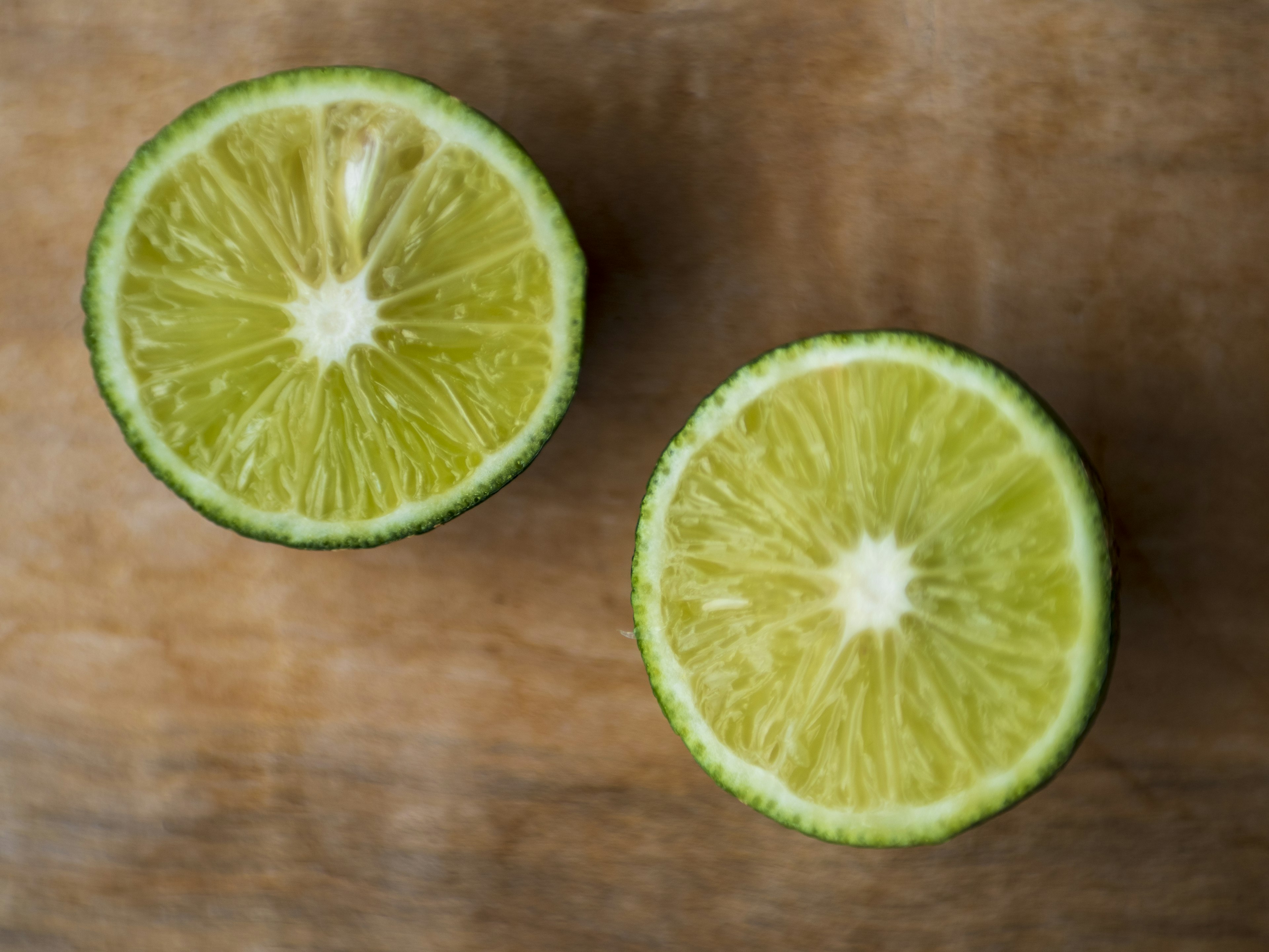 Deux citrons verts coupés sur une table en bois