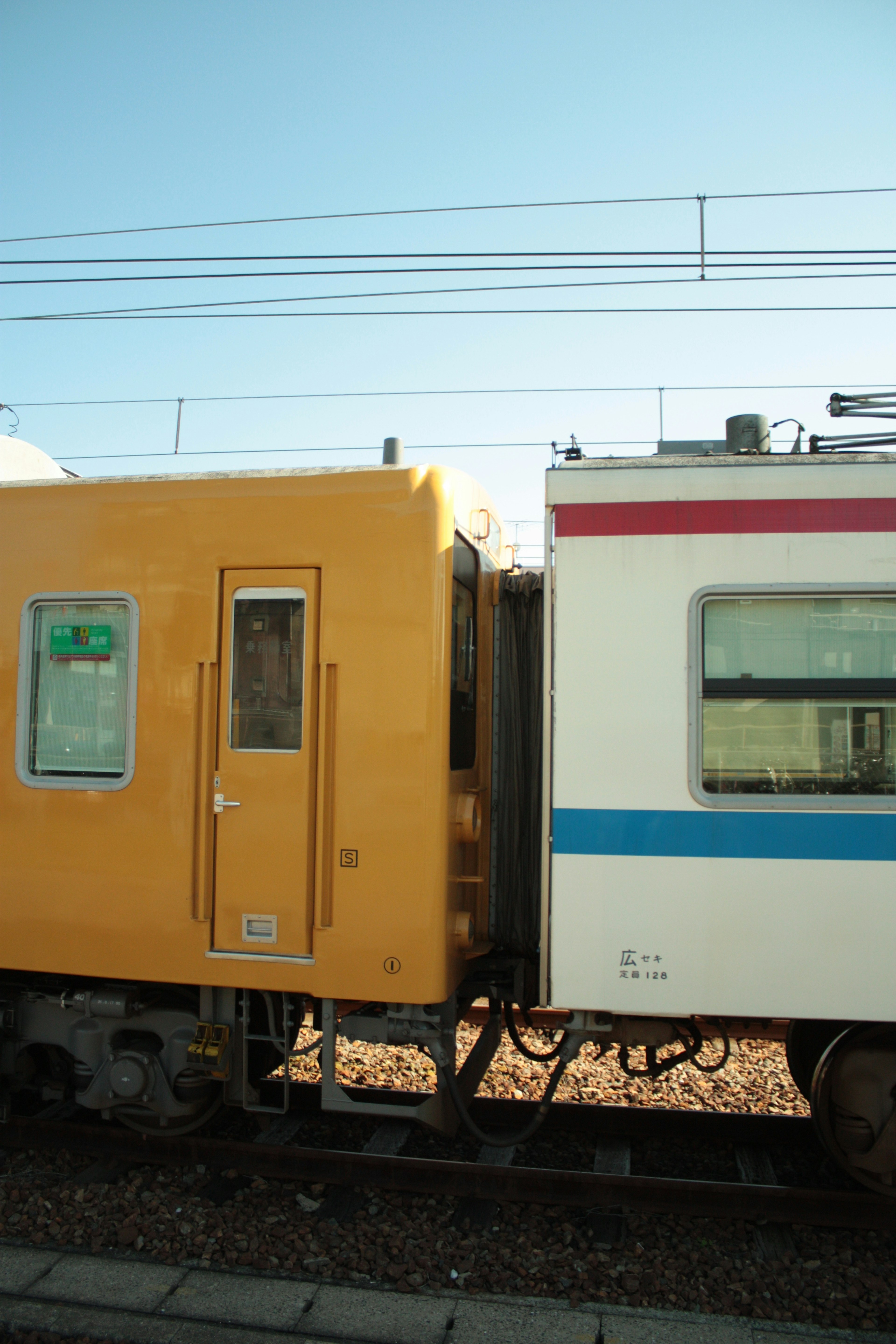 Nahaufnahme eines gelben Zugwagens, der mit einem weißen Zugwagen verbunden ist