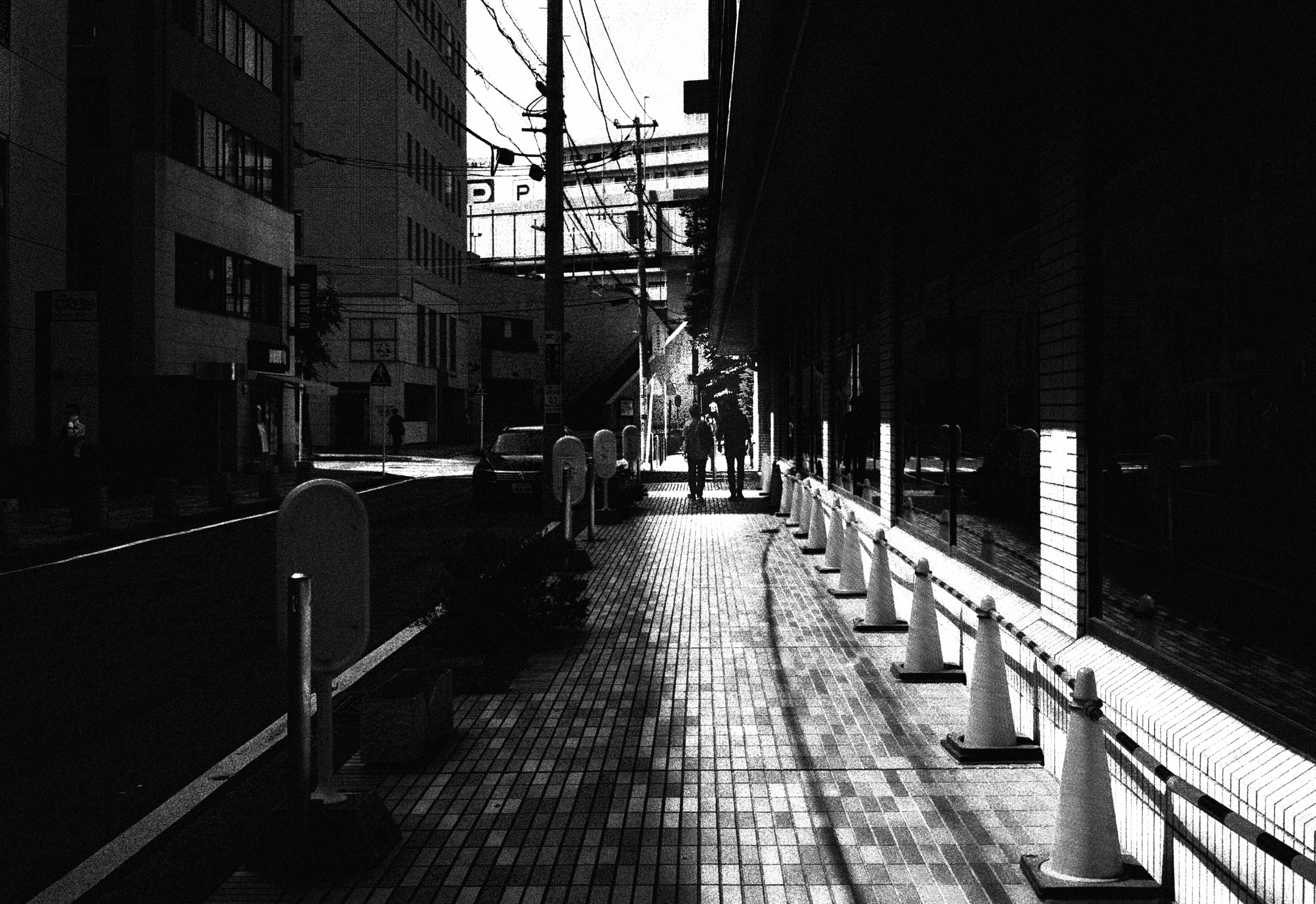 白黒の街路の風景、歩道と障害物が見える