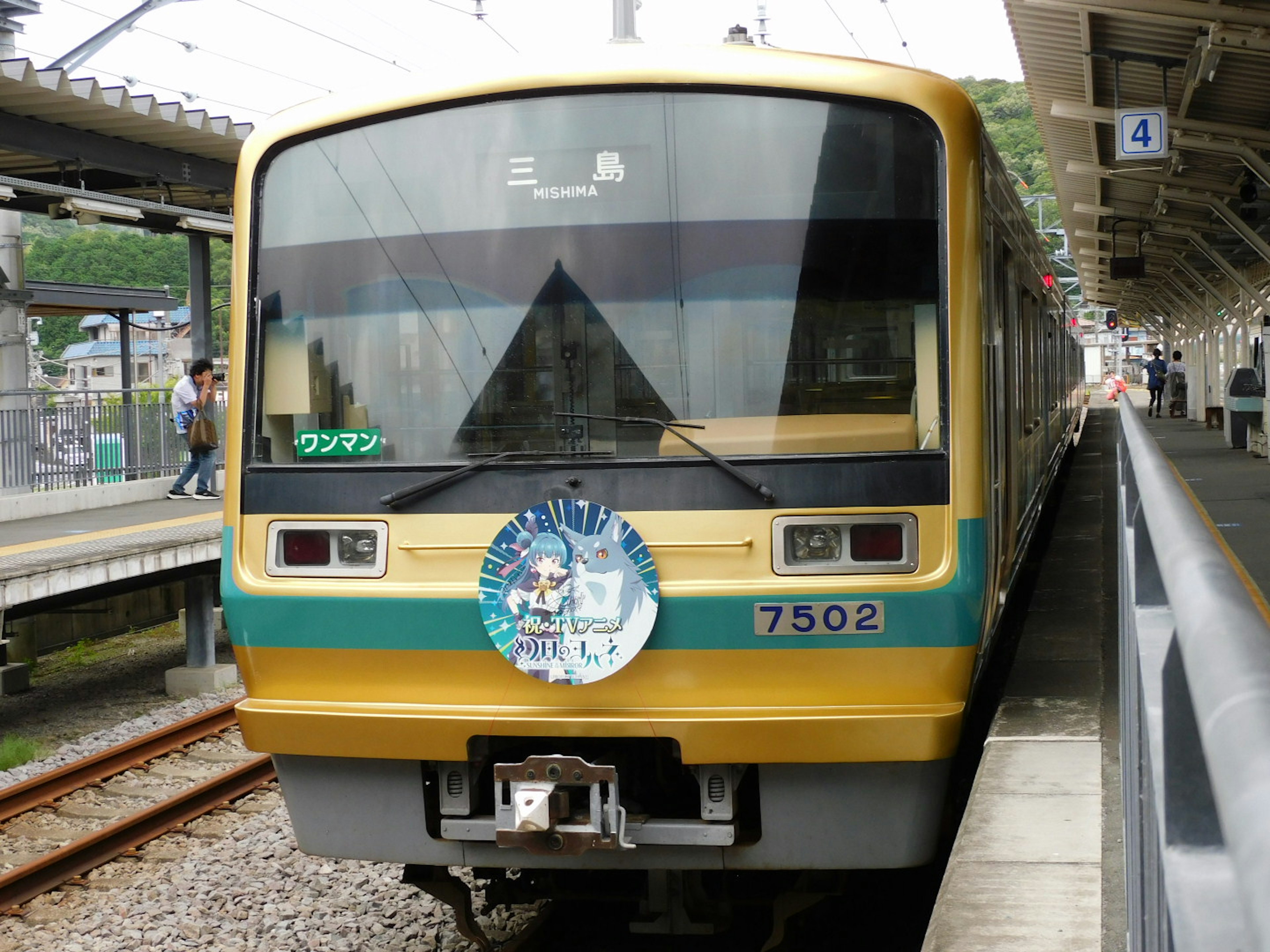 รถไฟสีเหลืองจอดที่สถานีพร้อมตราสัญลักษณ์ตกแต่ง