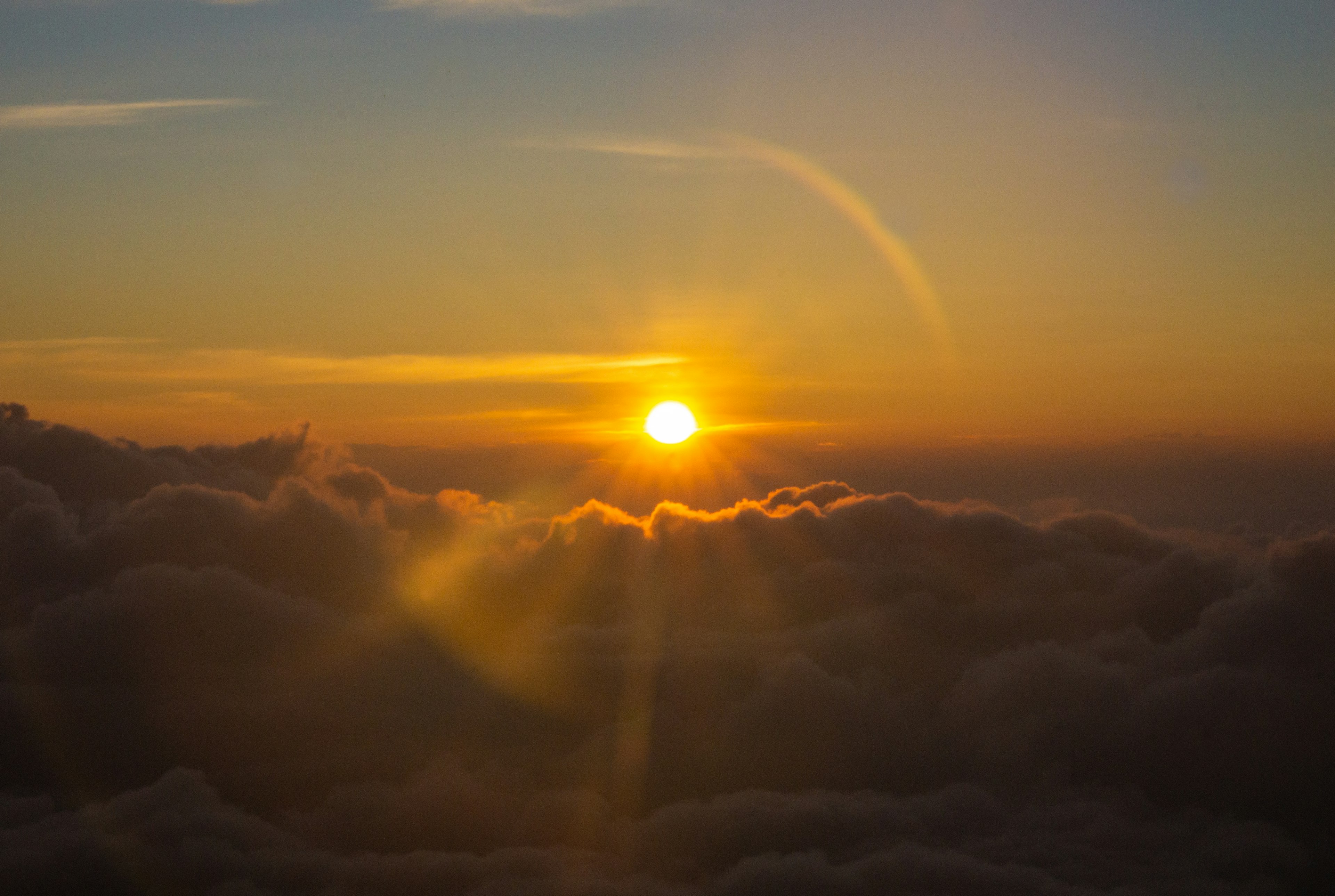 Sole splendido che sorge sopra le nuvole con un cielo arancione