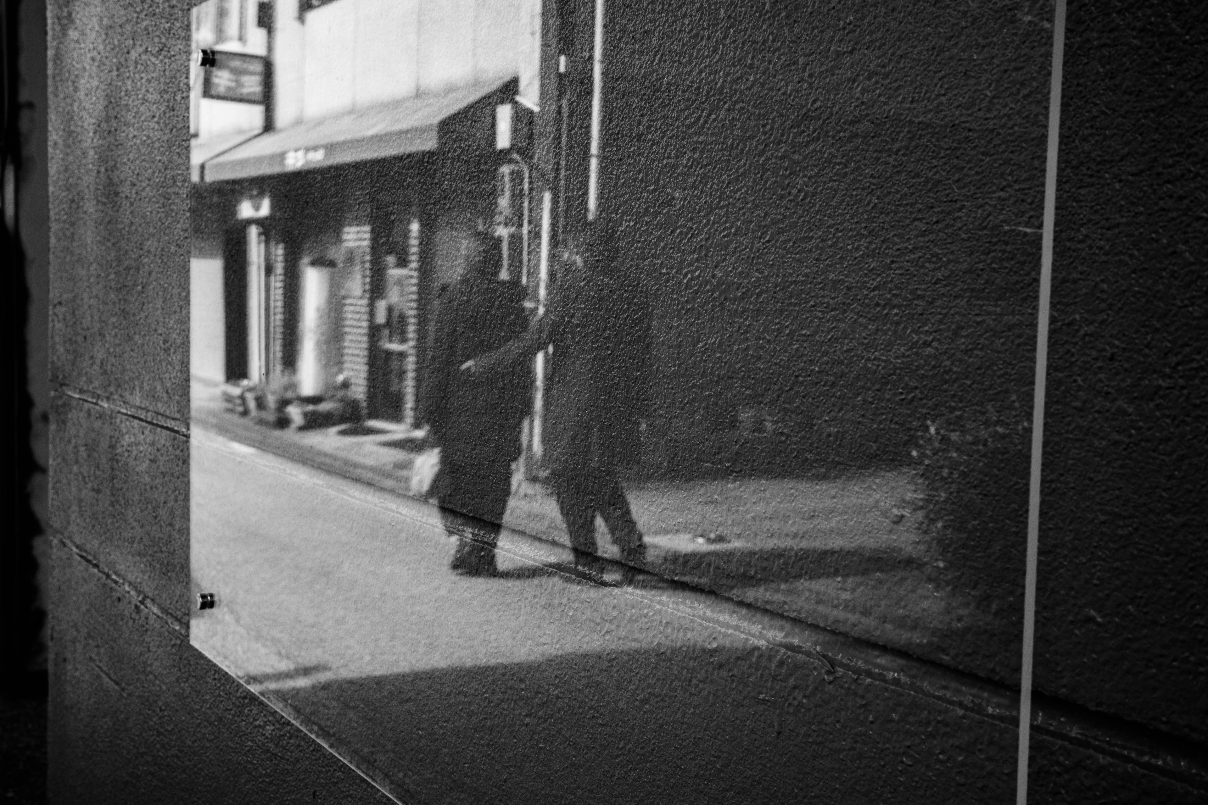 Image réfléchie de deux piétons marchant dans un cadre urbain