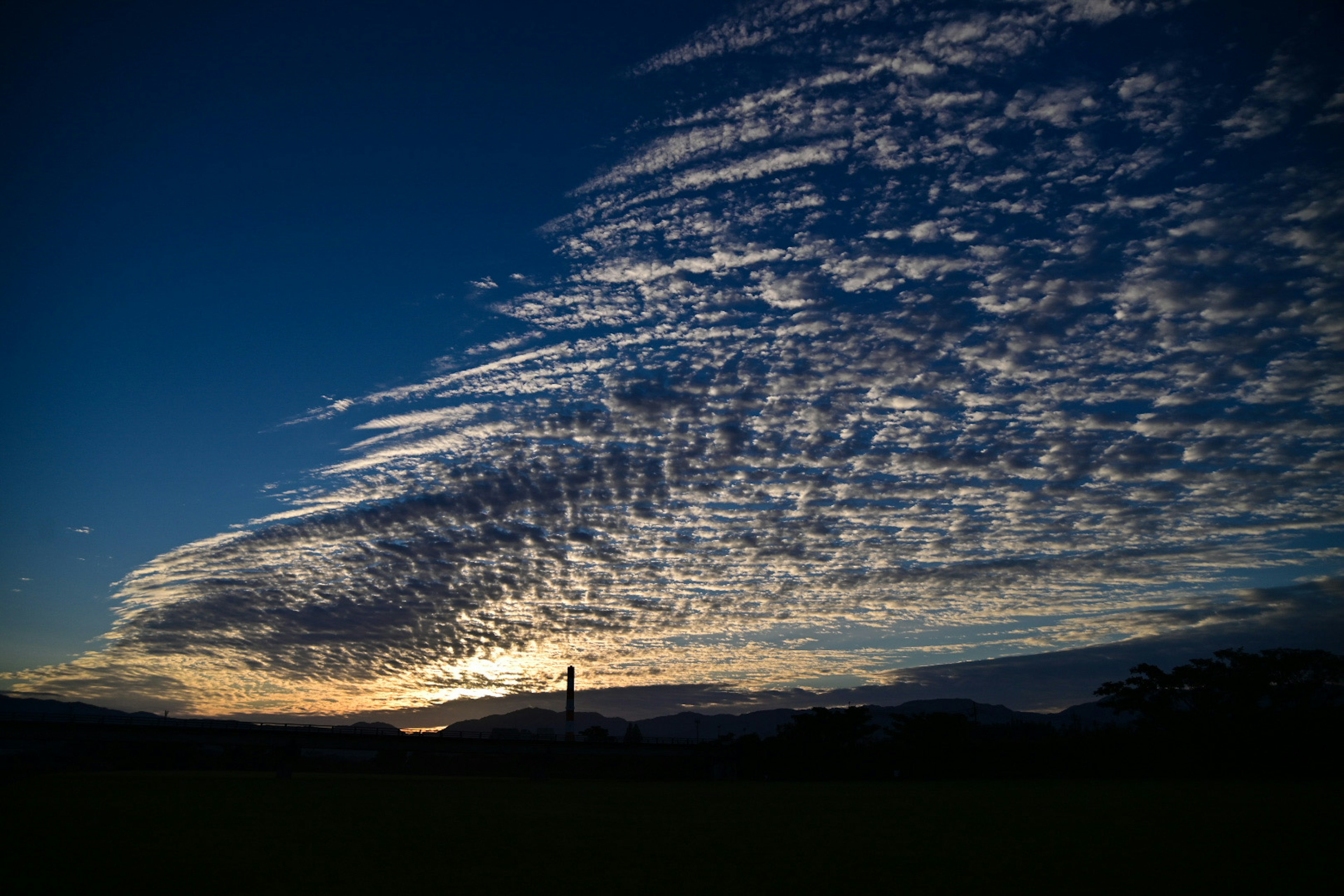 美しい夕焼けの空に広がる波状の雲