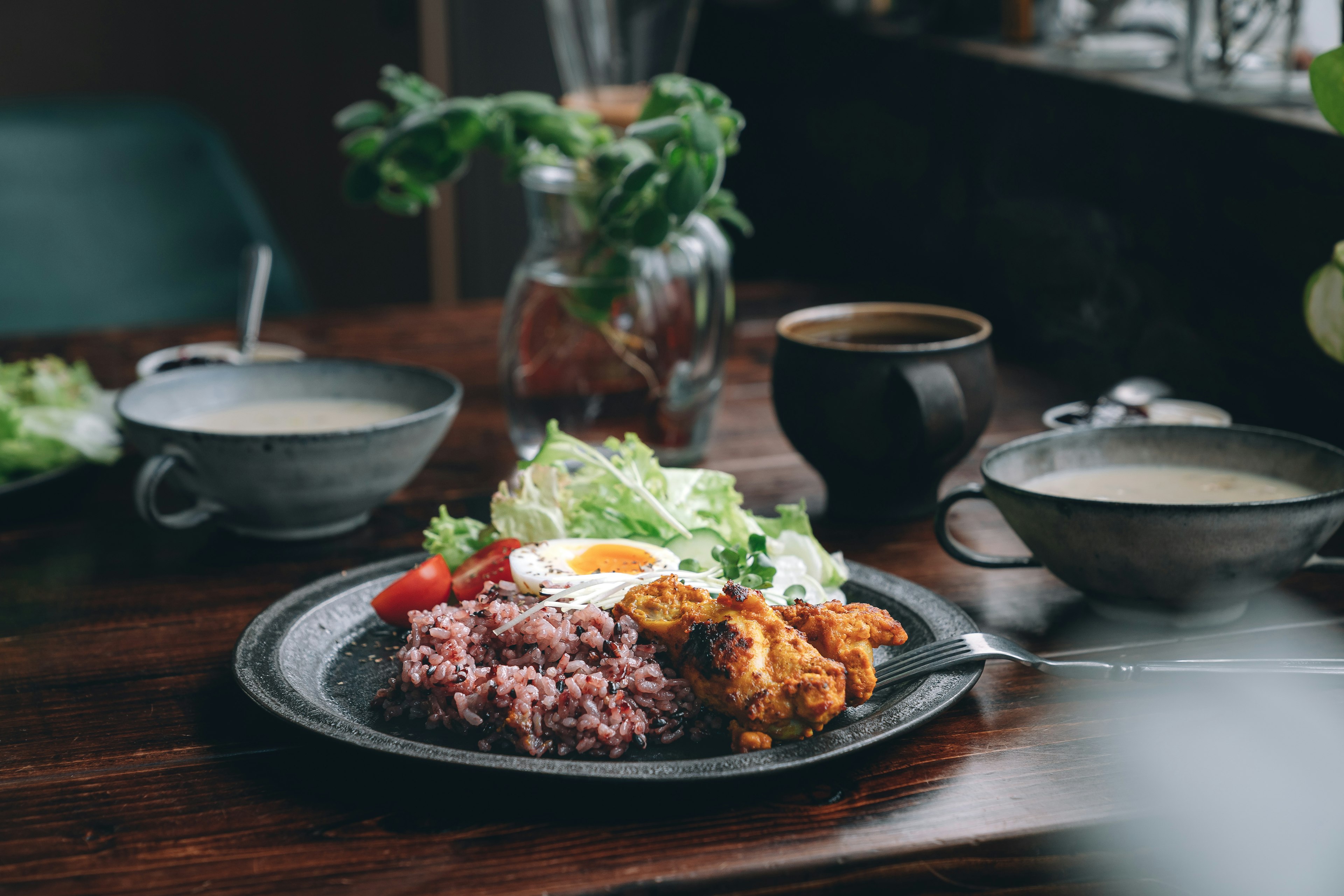 바삭한 치킨, 샐러드, 계란 후라이가 있는 맛있는 보라색 쌀 접시