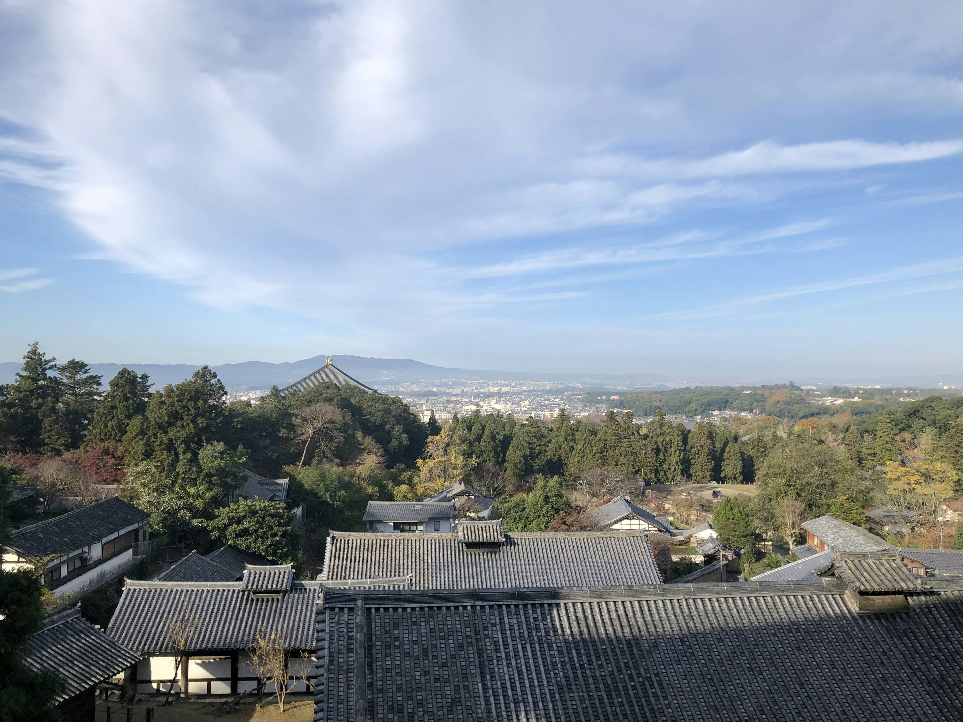 Scenic view of traditional Japanese buildings with mountains and blue sky