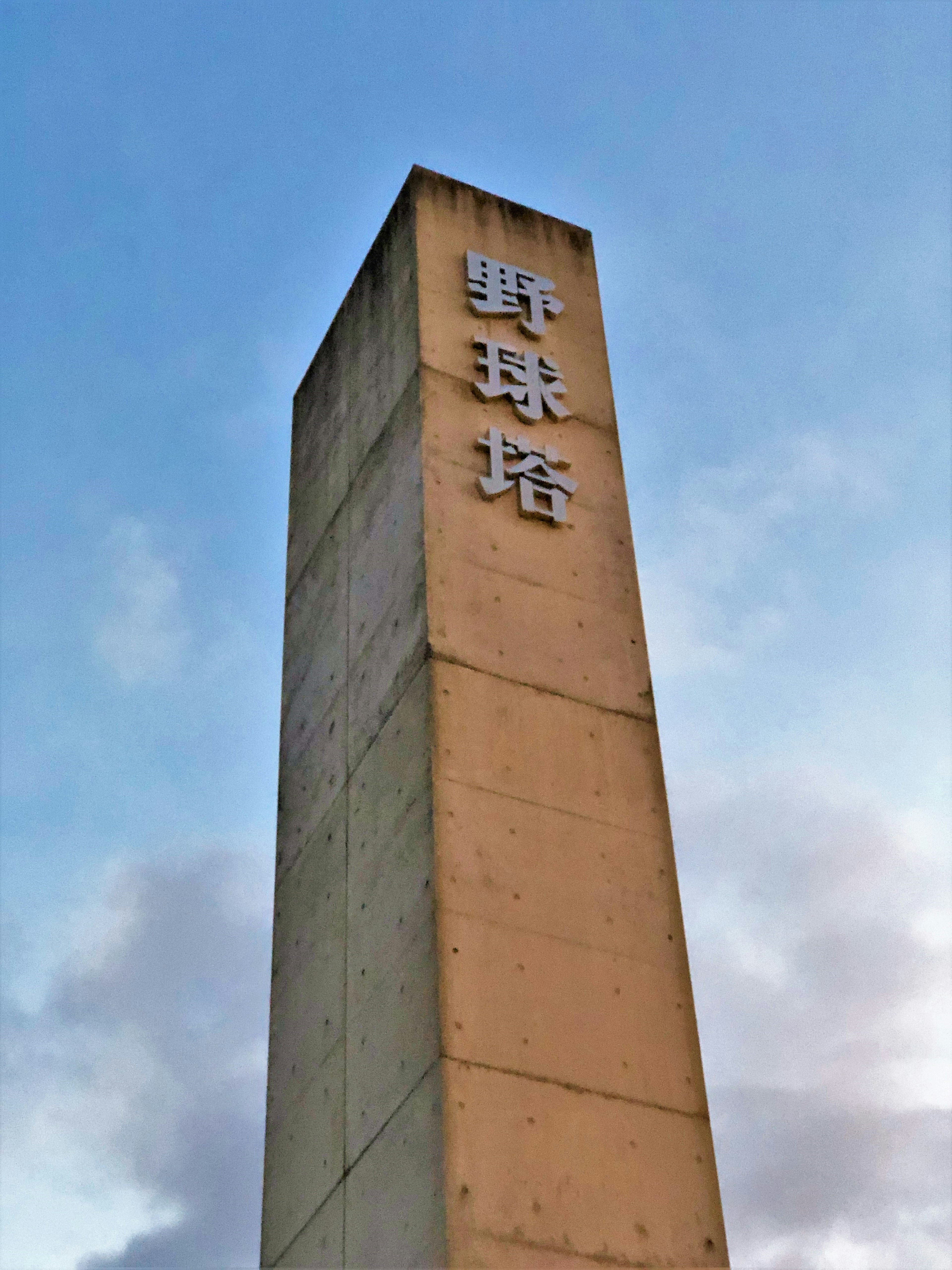 Concrete tower of a baseball field stands under a blue sky