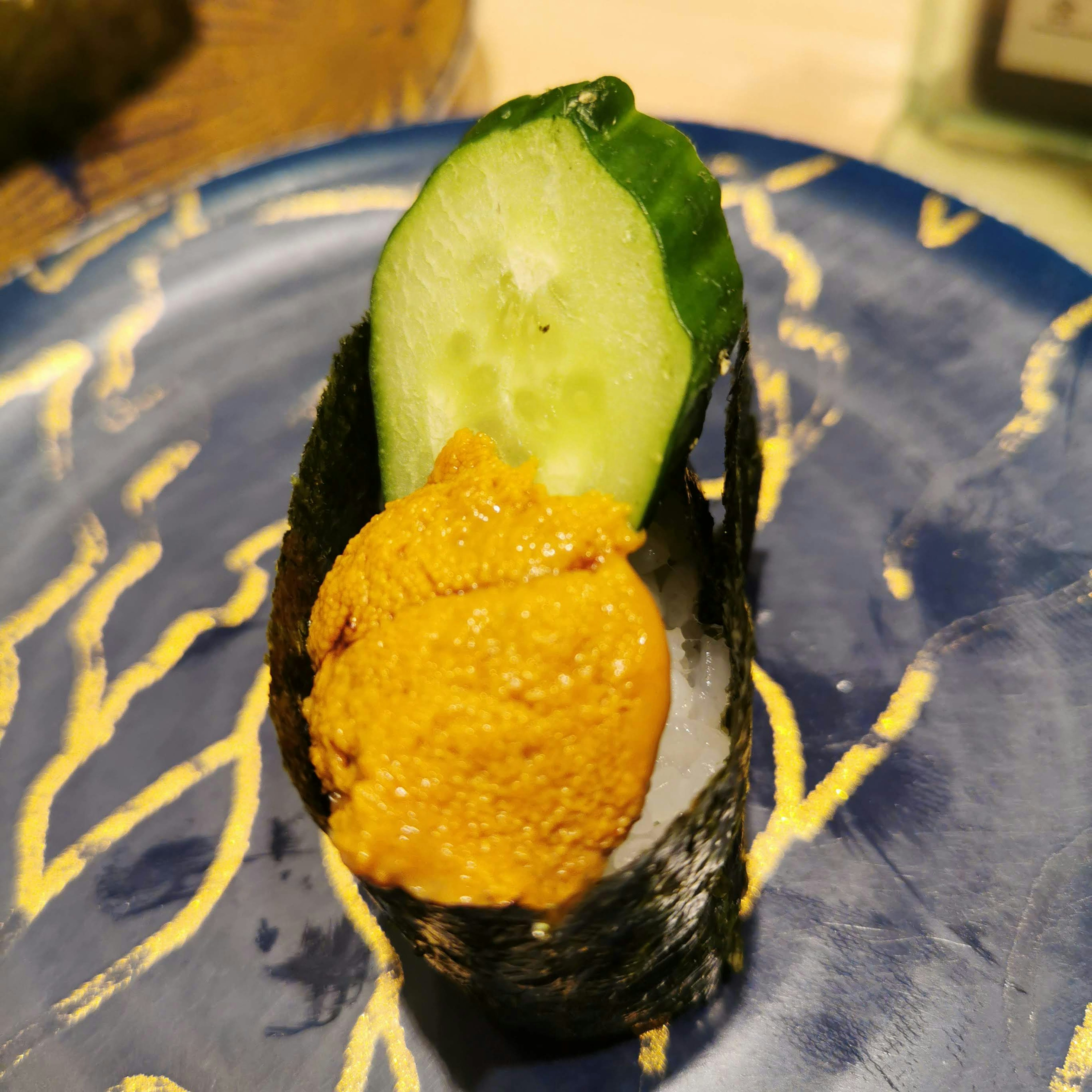 Sushi featuring seaweed topped with cucumber and sea urchin