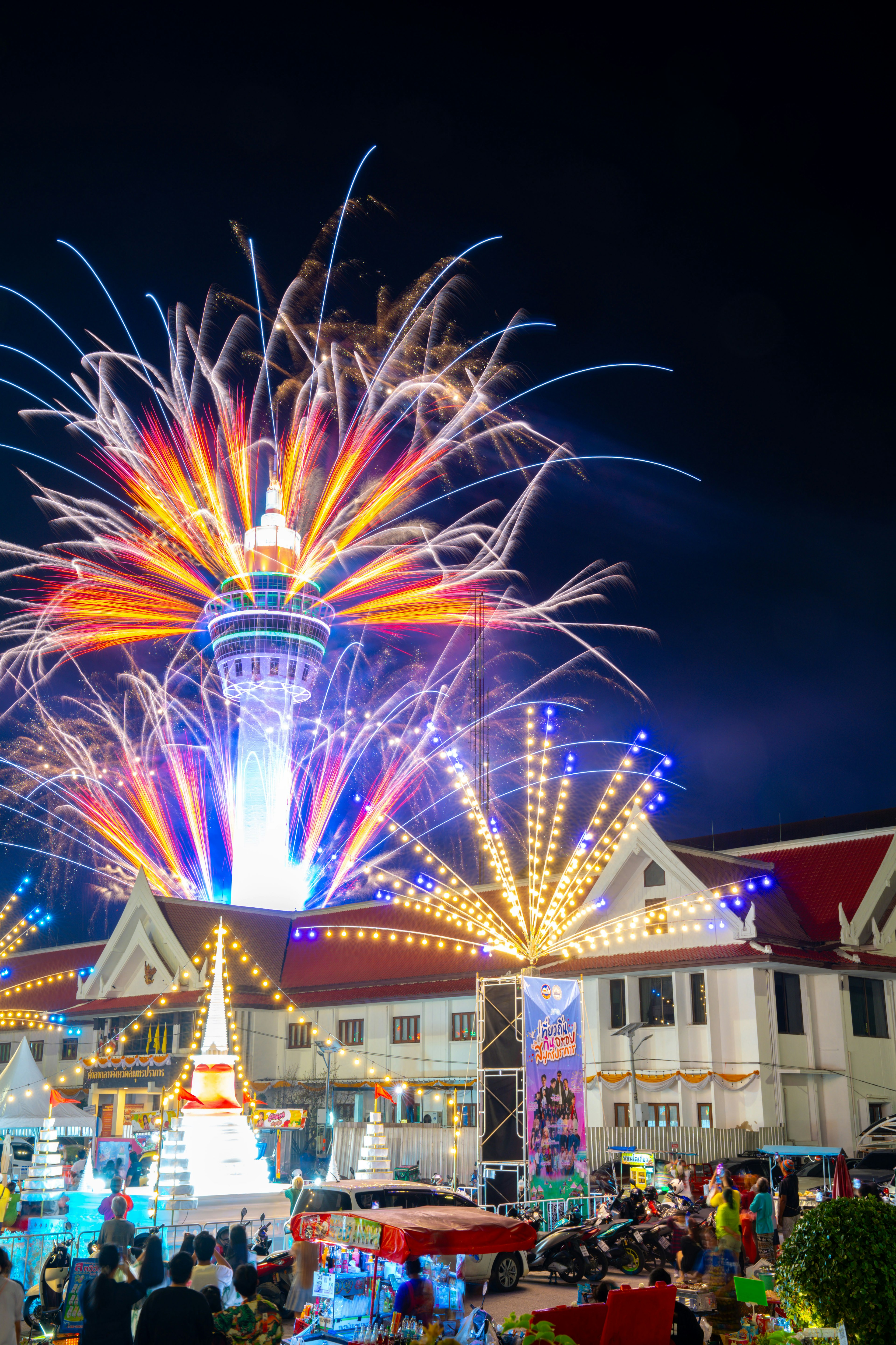 Scène de festival vibrante avec des feux d'artifice illuminant le ciel nocturne