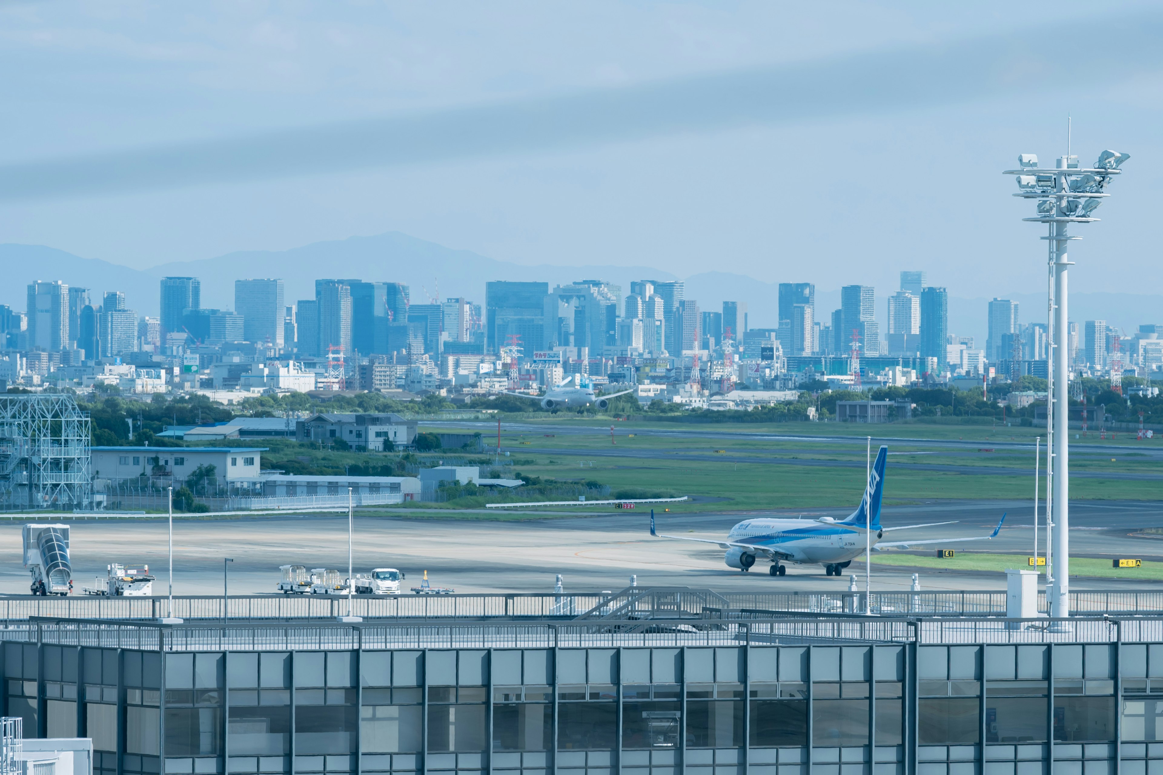 Pista de aeropuerto con horizonte de ciudad moderna