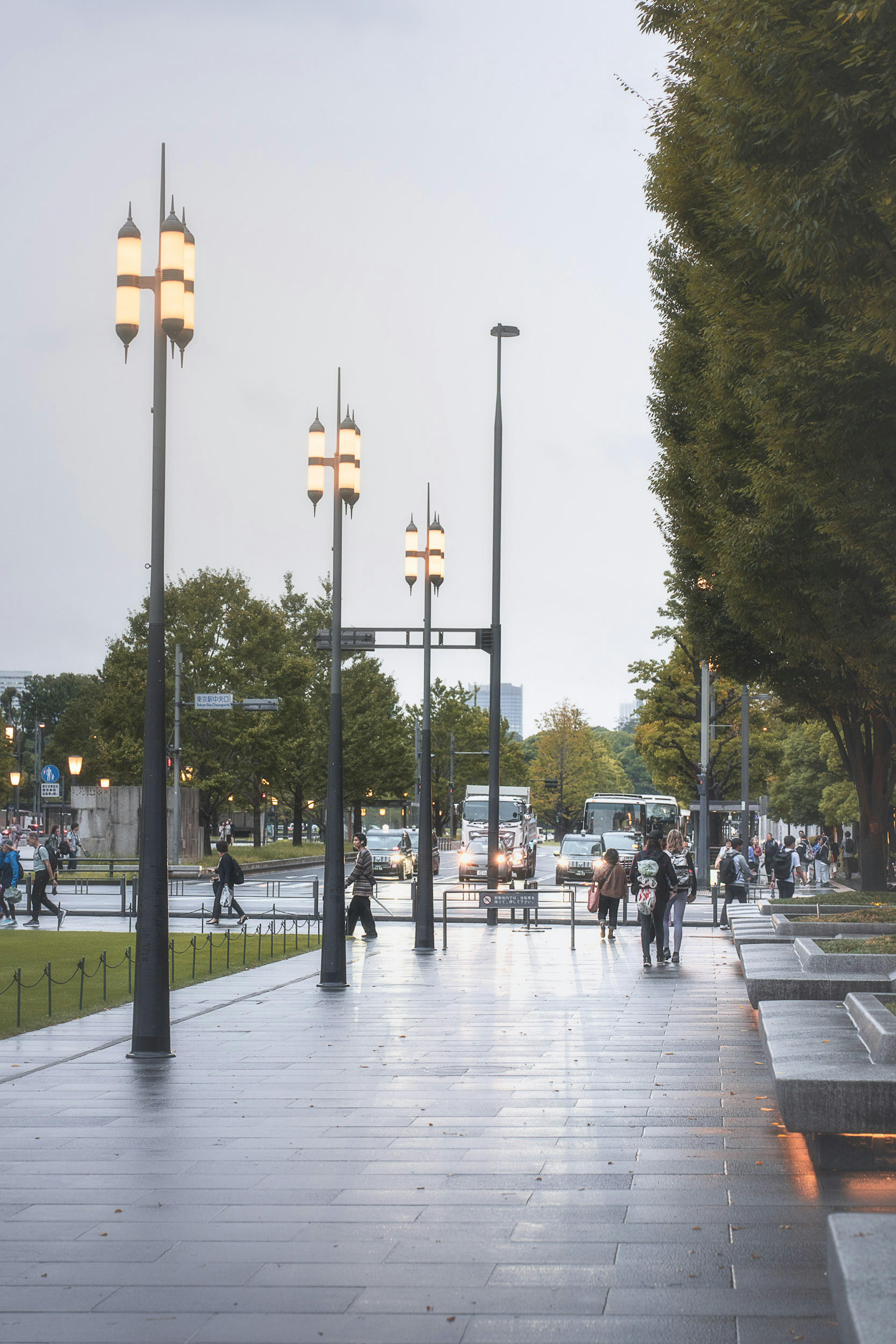 Street scene with lampposts and pedestrians in the rain