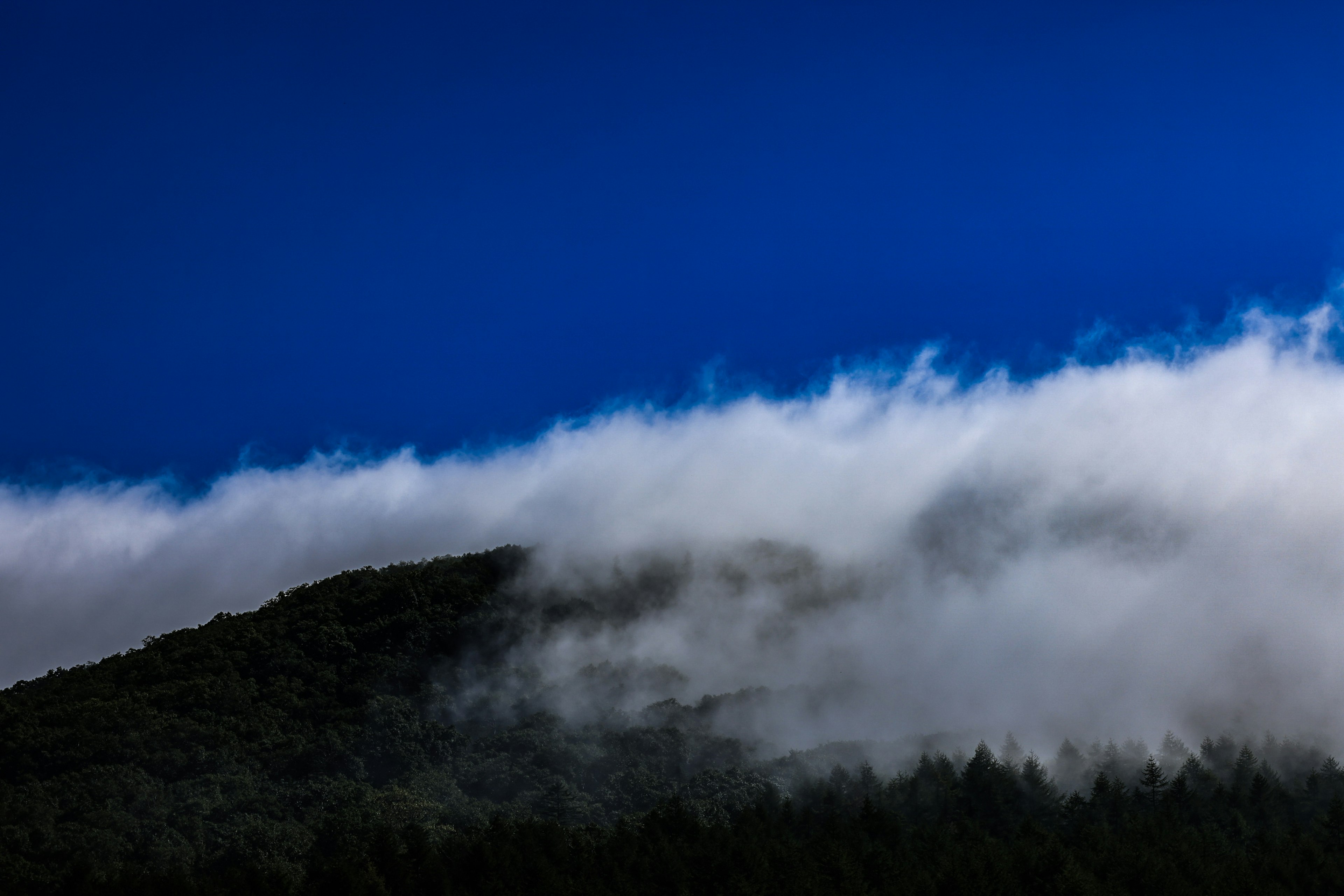 Pemandangan pegunungan dengan langit biru dan awan