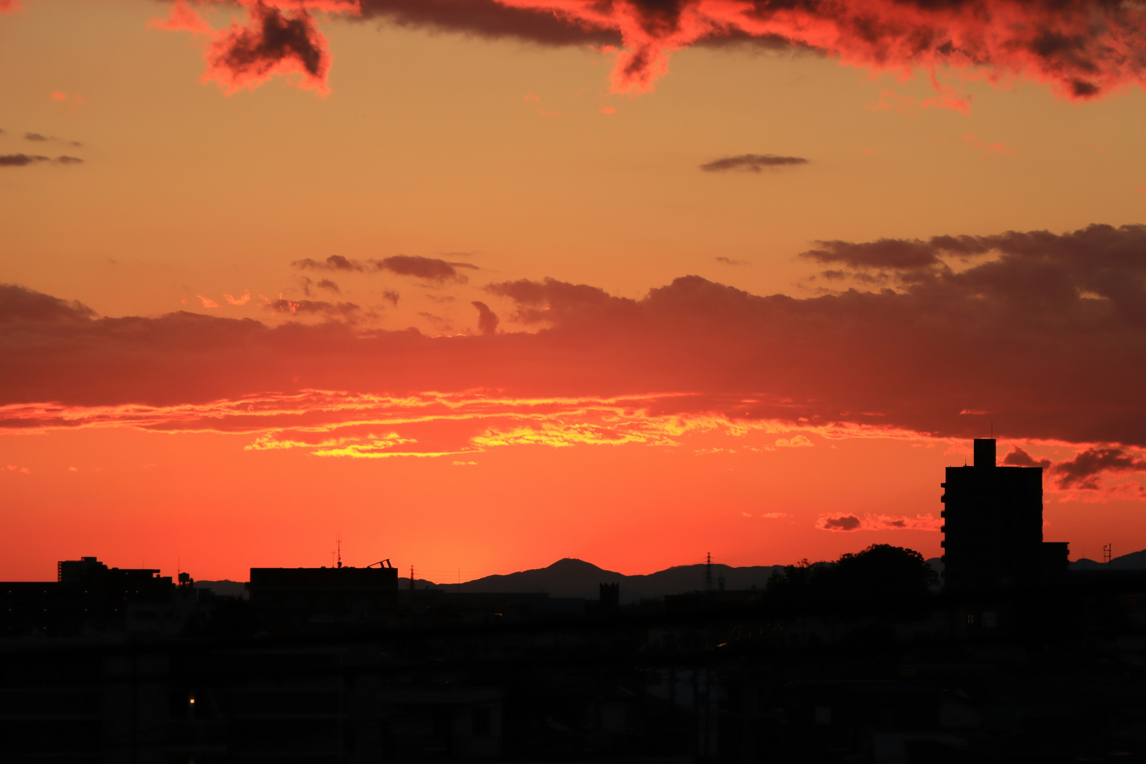 Silhouette von Gebäuden vor einem lebhaften Sonnenuntergangshimmel