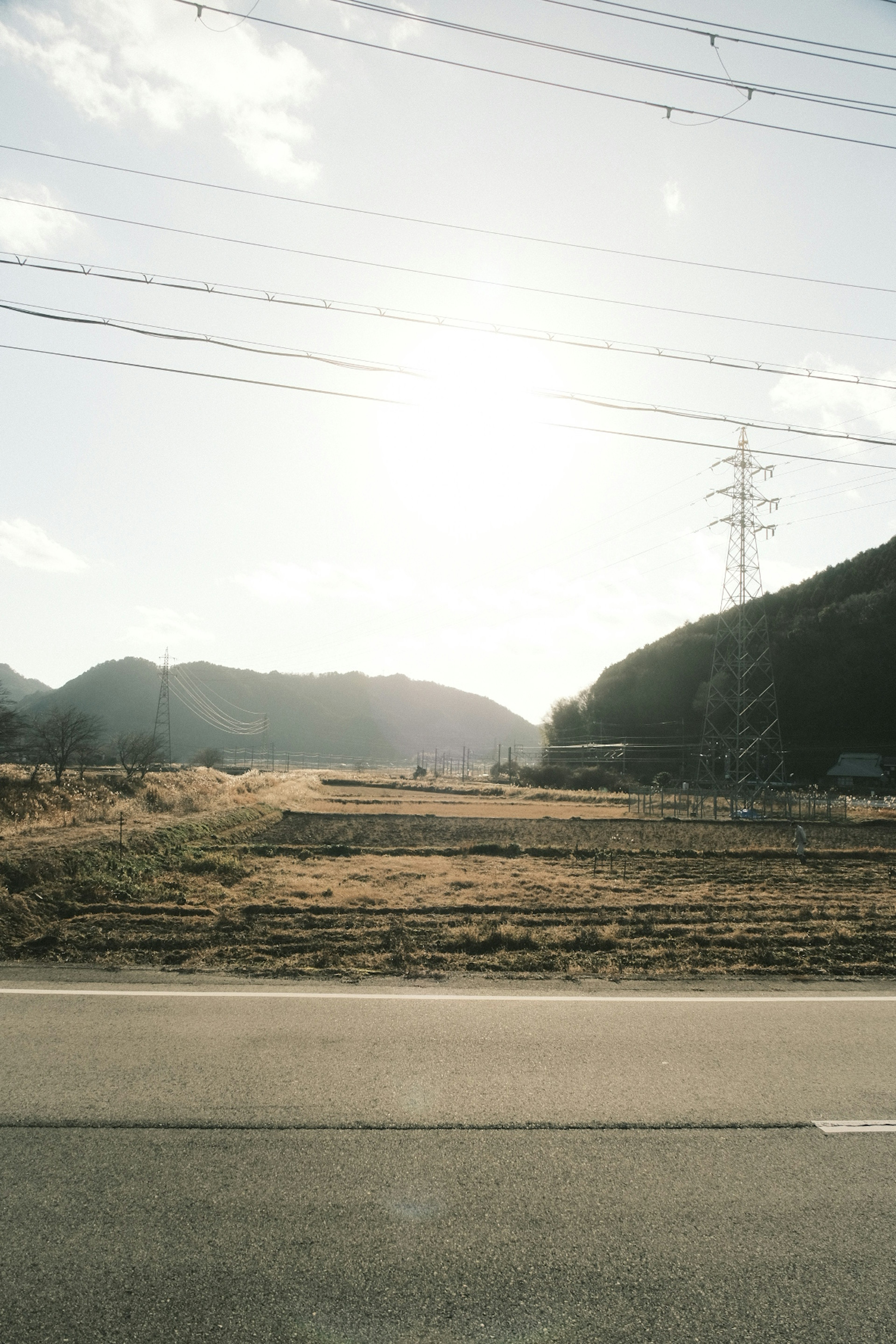 広い土地と山々の景色に日差しが差し込む風景