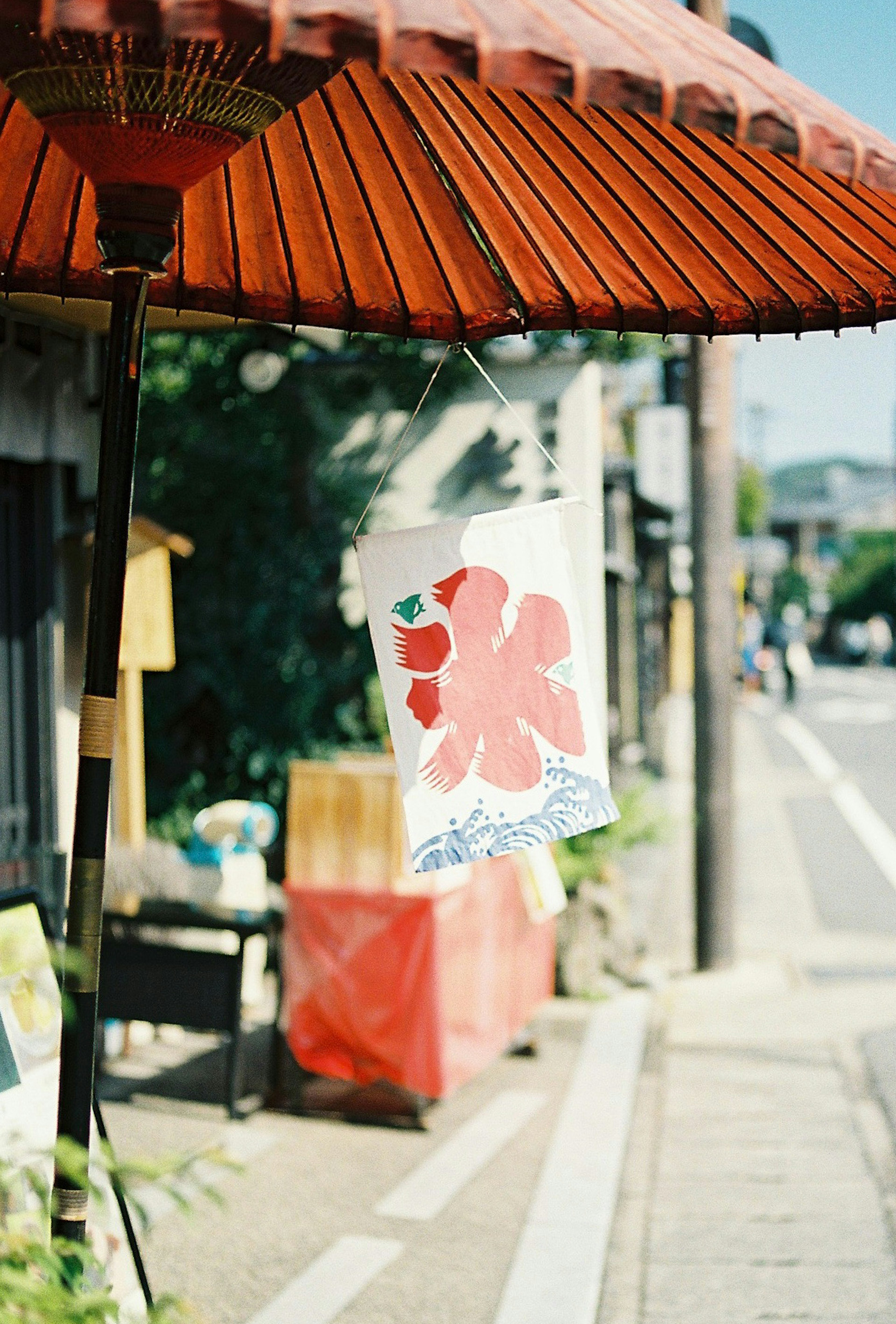 Red flower painting on a hanging lantern with a traditional street view