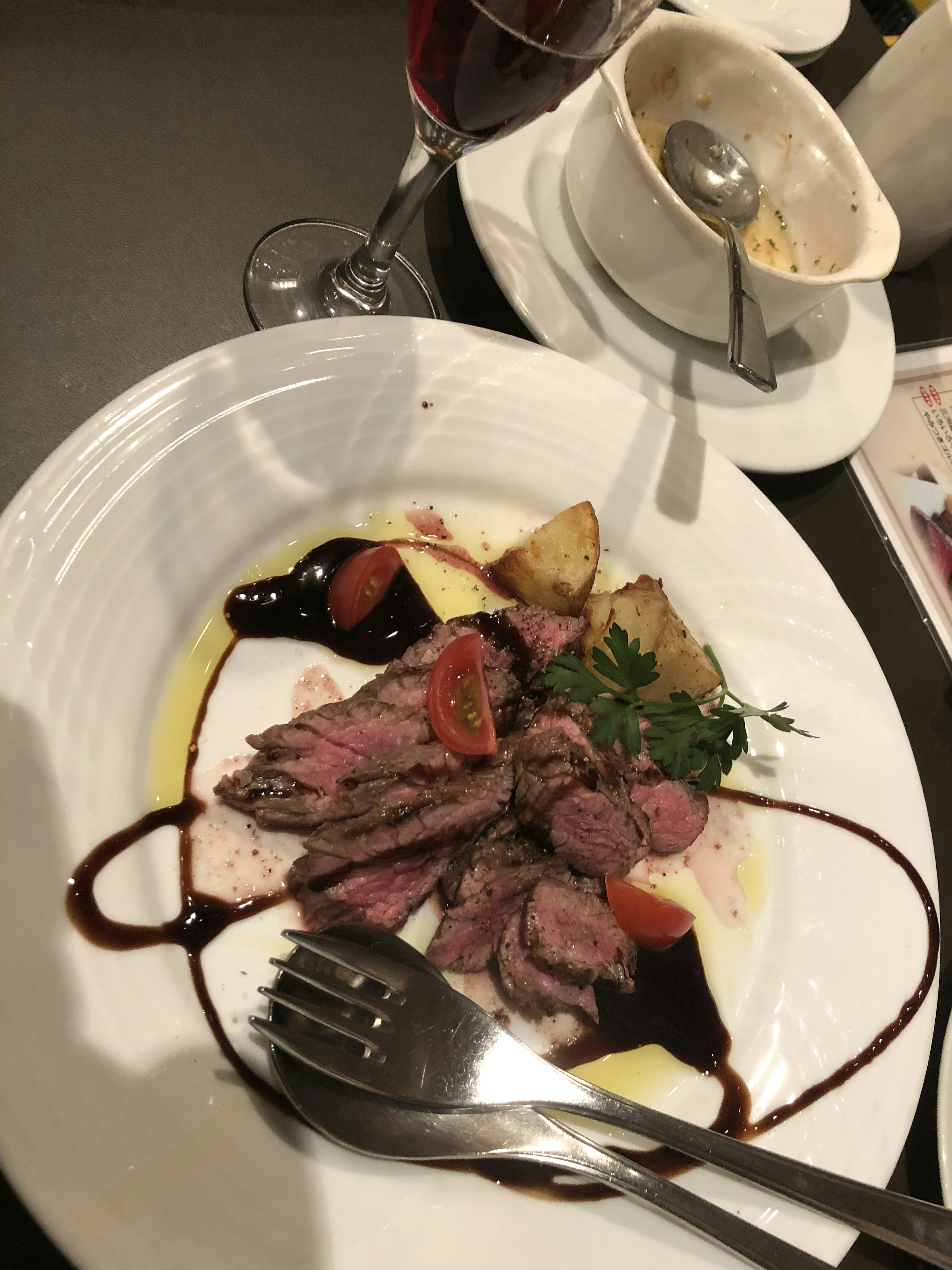 Deliciously plated beef dish with potatoes and garnishes on a white plate