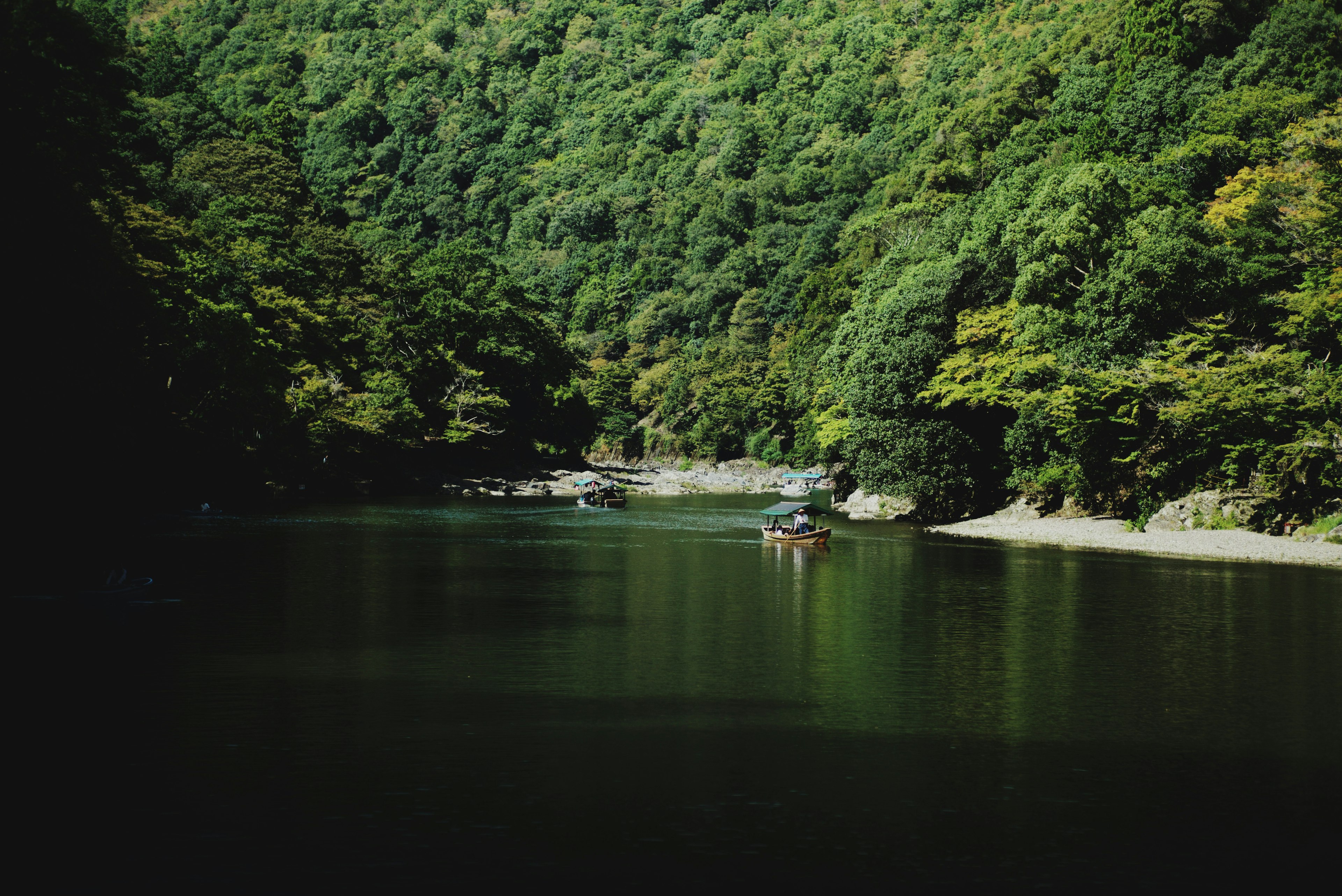 Ruhige Flusslandschaft mit üppigen grünen Bergen und einem kleinen Boot