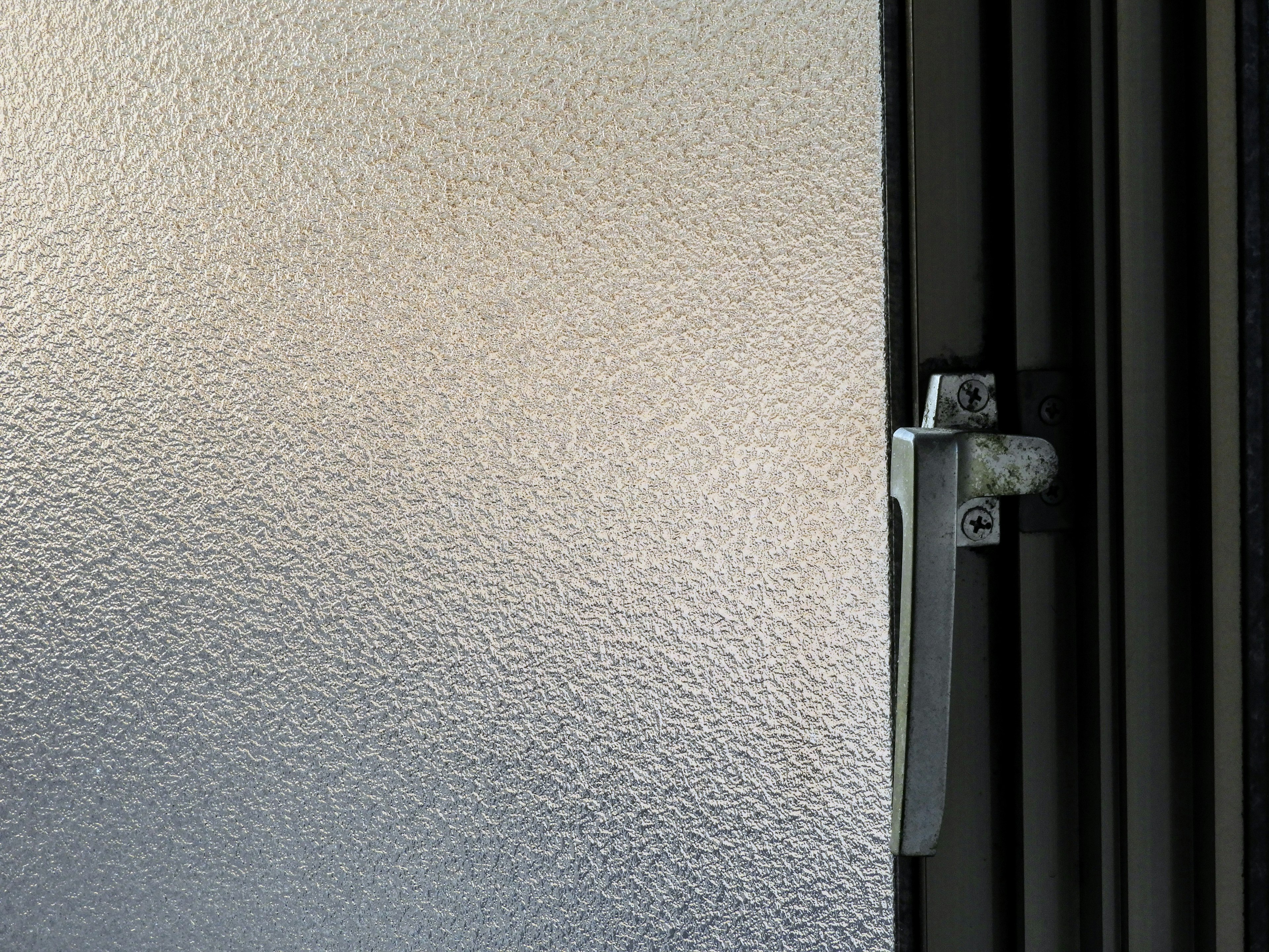 Close-up of a frosted glass door with a metal handle