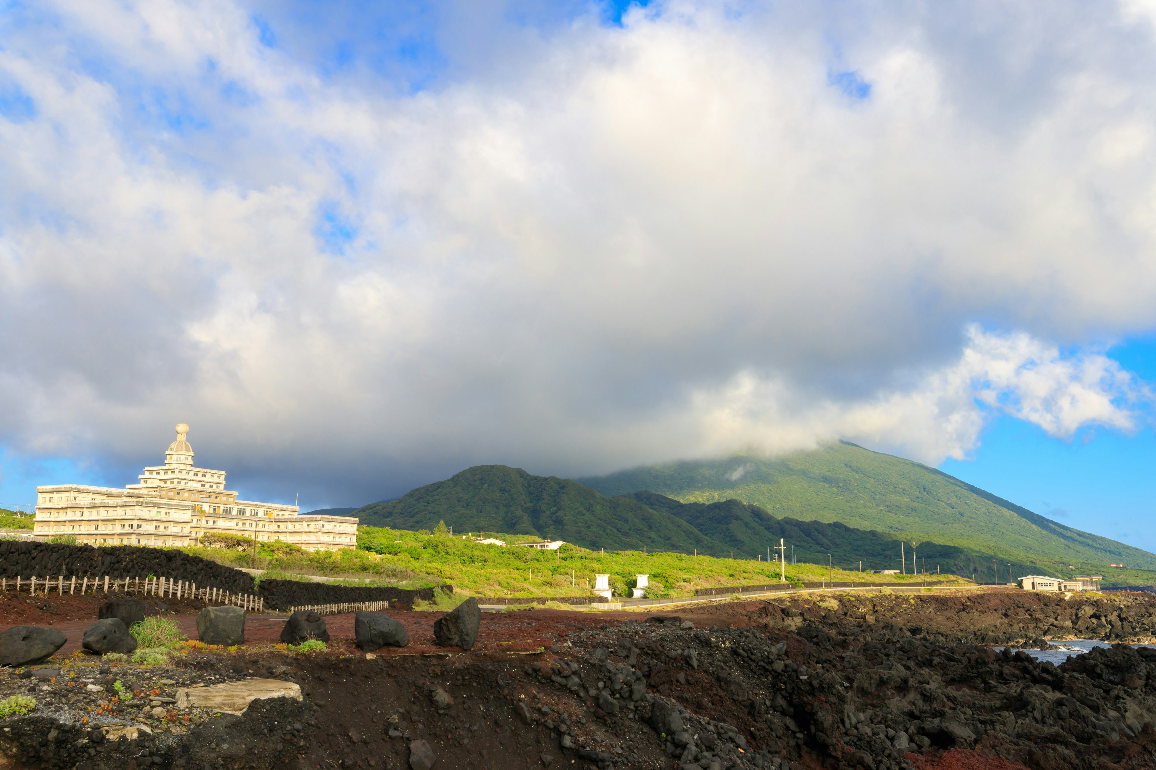 大きな山と青空の下にある石造りの建物