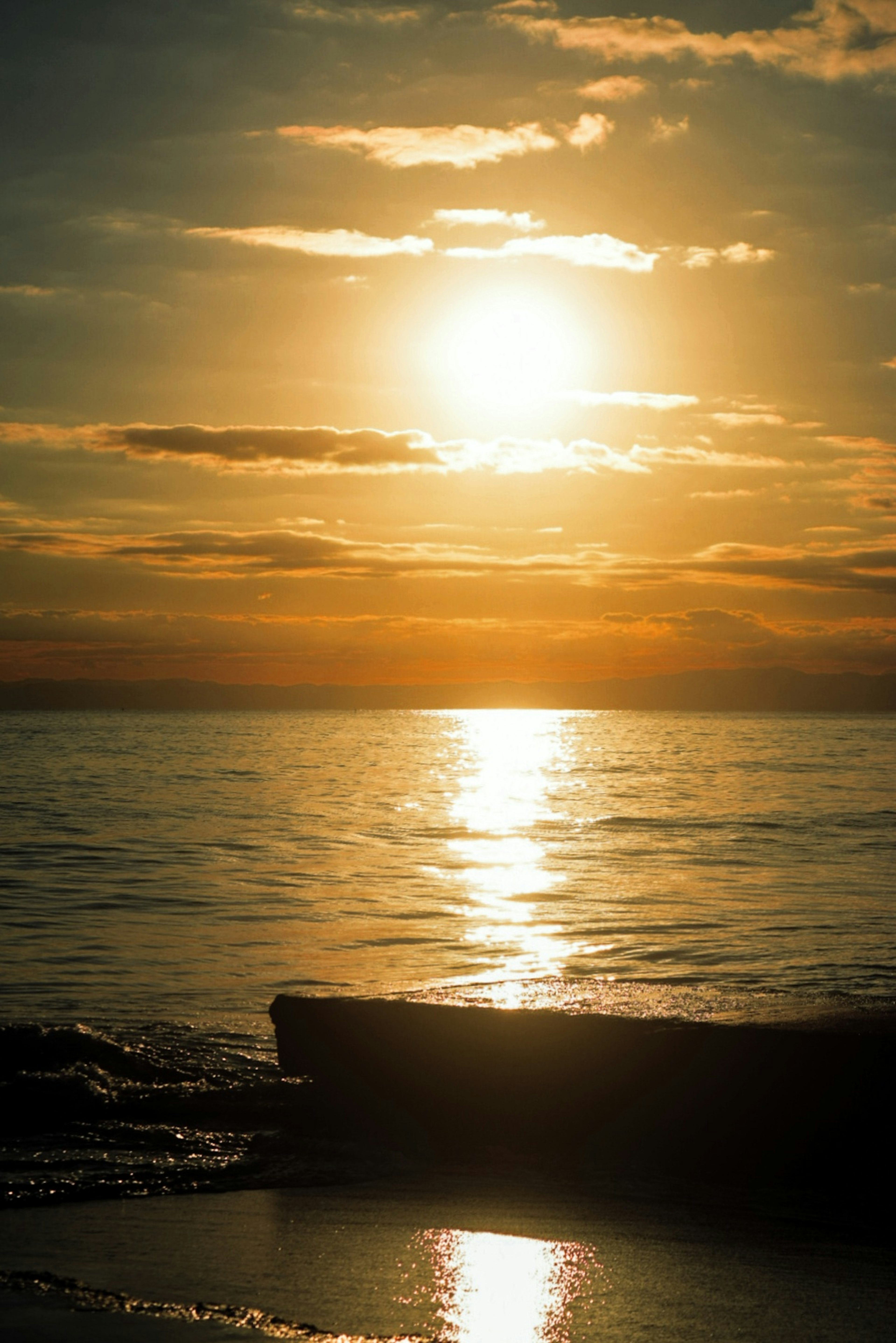 Bellissimo tramonto che si riflette sul mare con una barca in silhouette