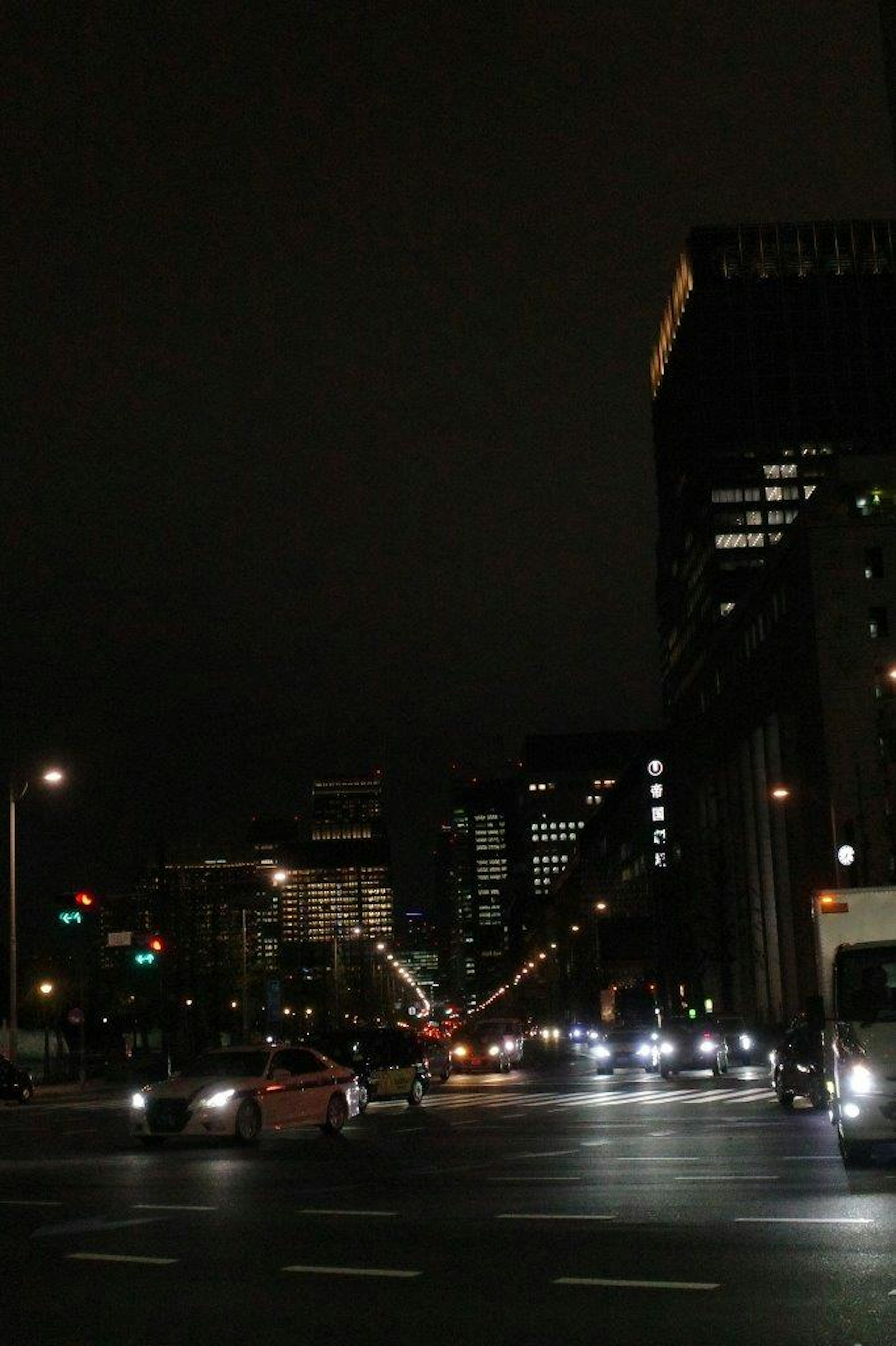 Paisaje urbano nocturno con luces de coches y edificios