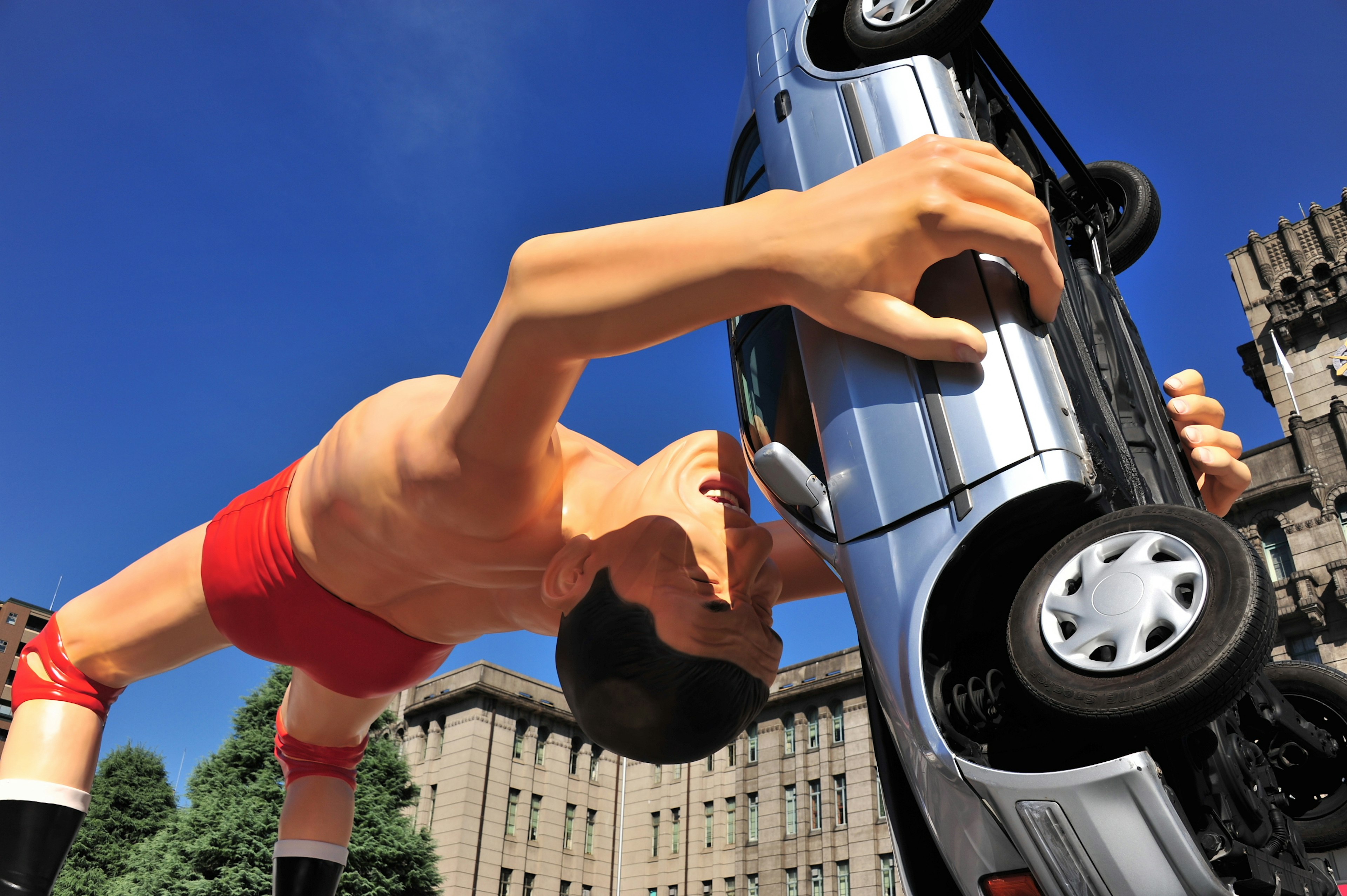 Giant wrestler lifting a car in a unique art installation