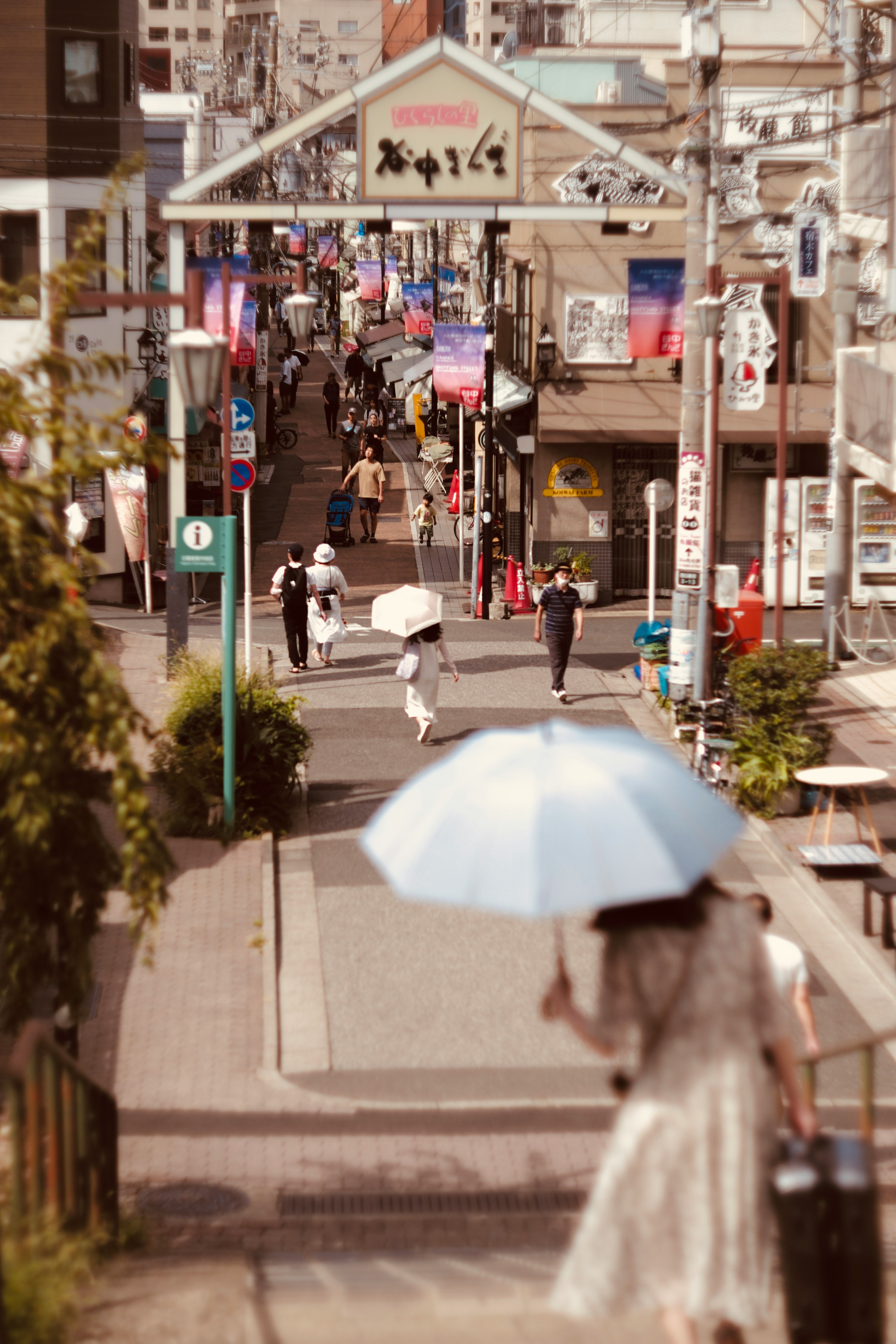 人々が傘を持って歩く商店街の風景