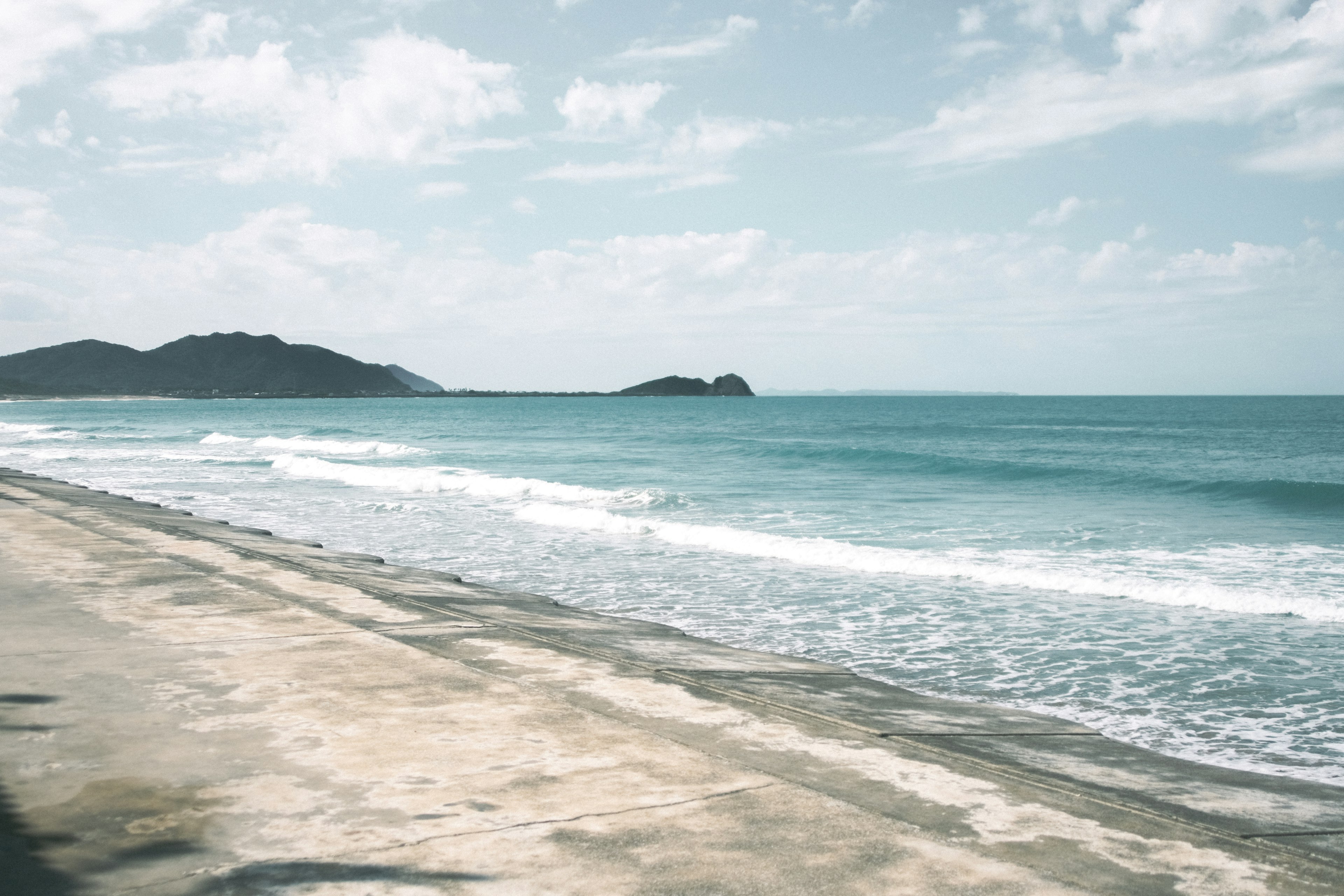 宁静的海滩景观，海面平静，天空湛蓝