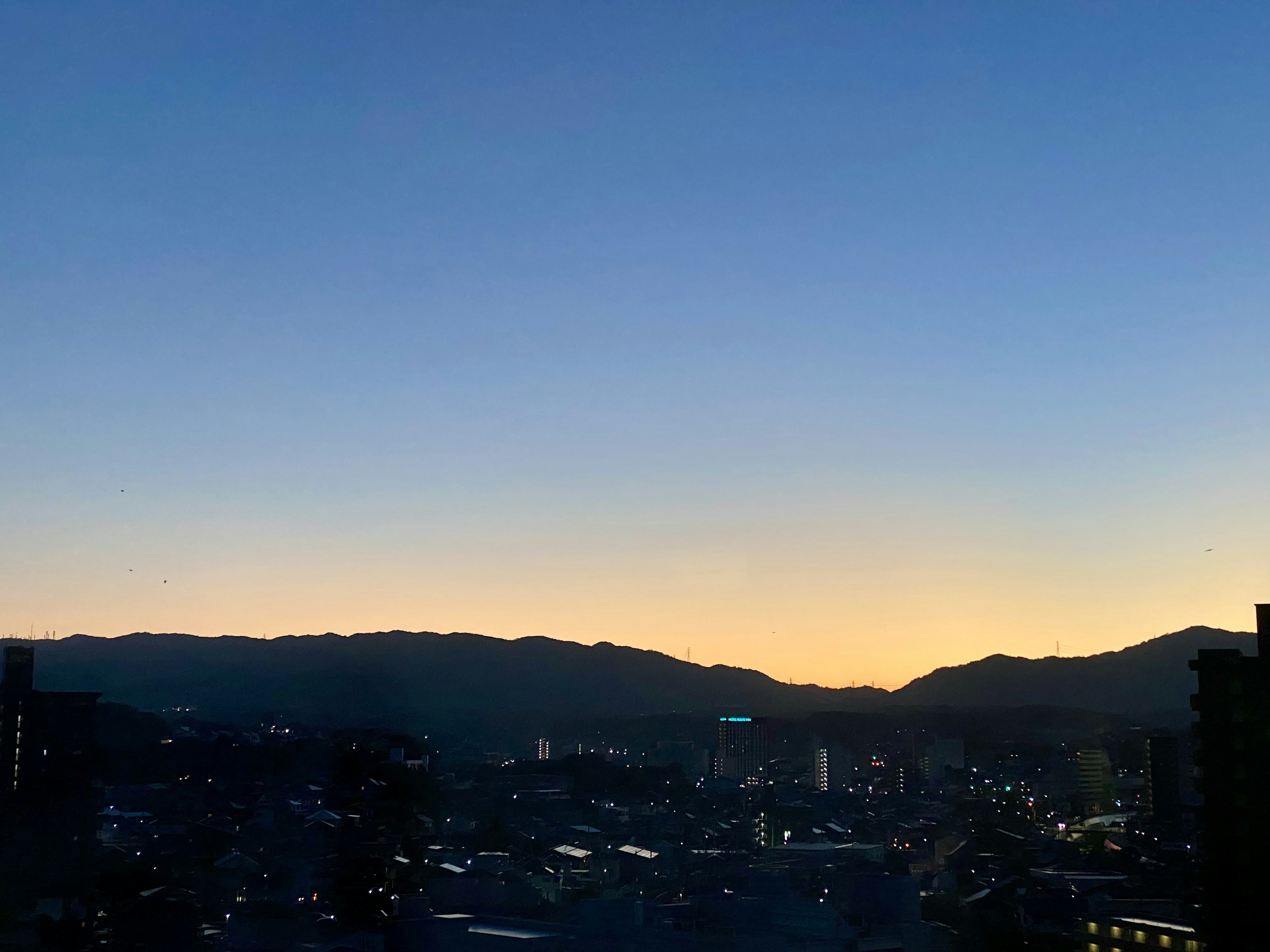 Pemandangan kota tenang saat senja dengan langit gradasi