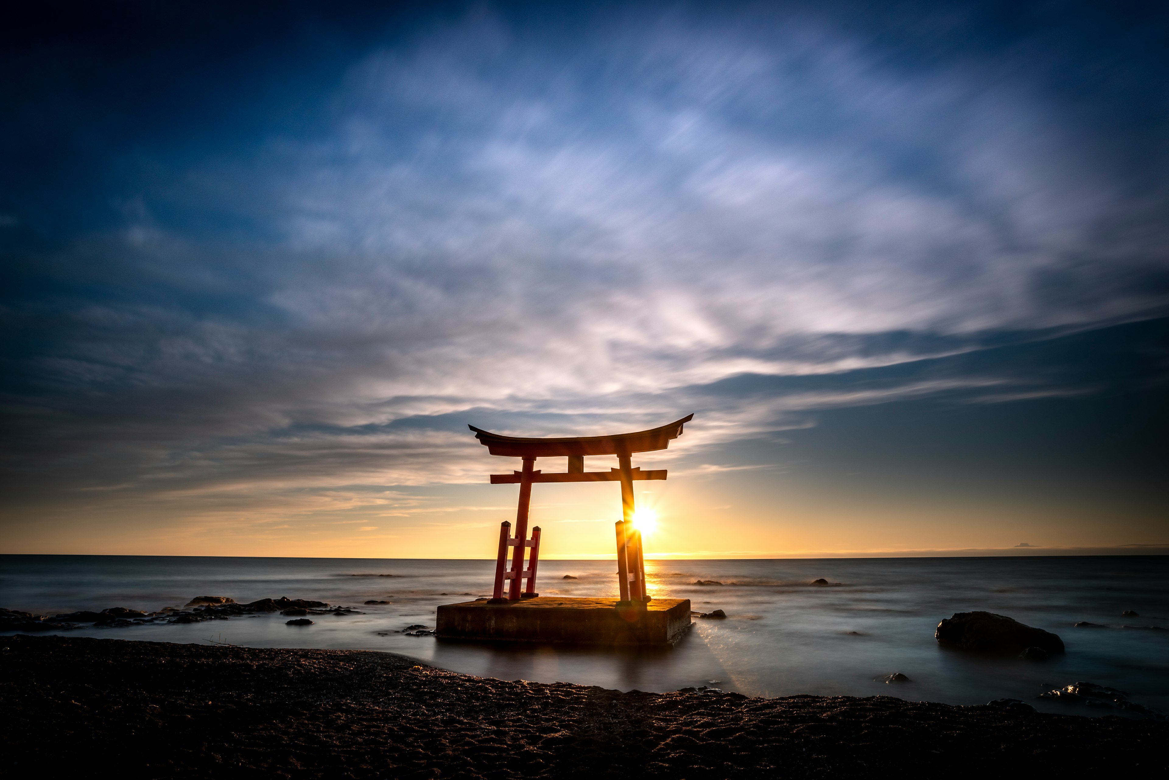 海に浮かぶ鳥居と夕日の風景