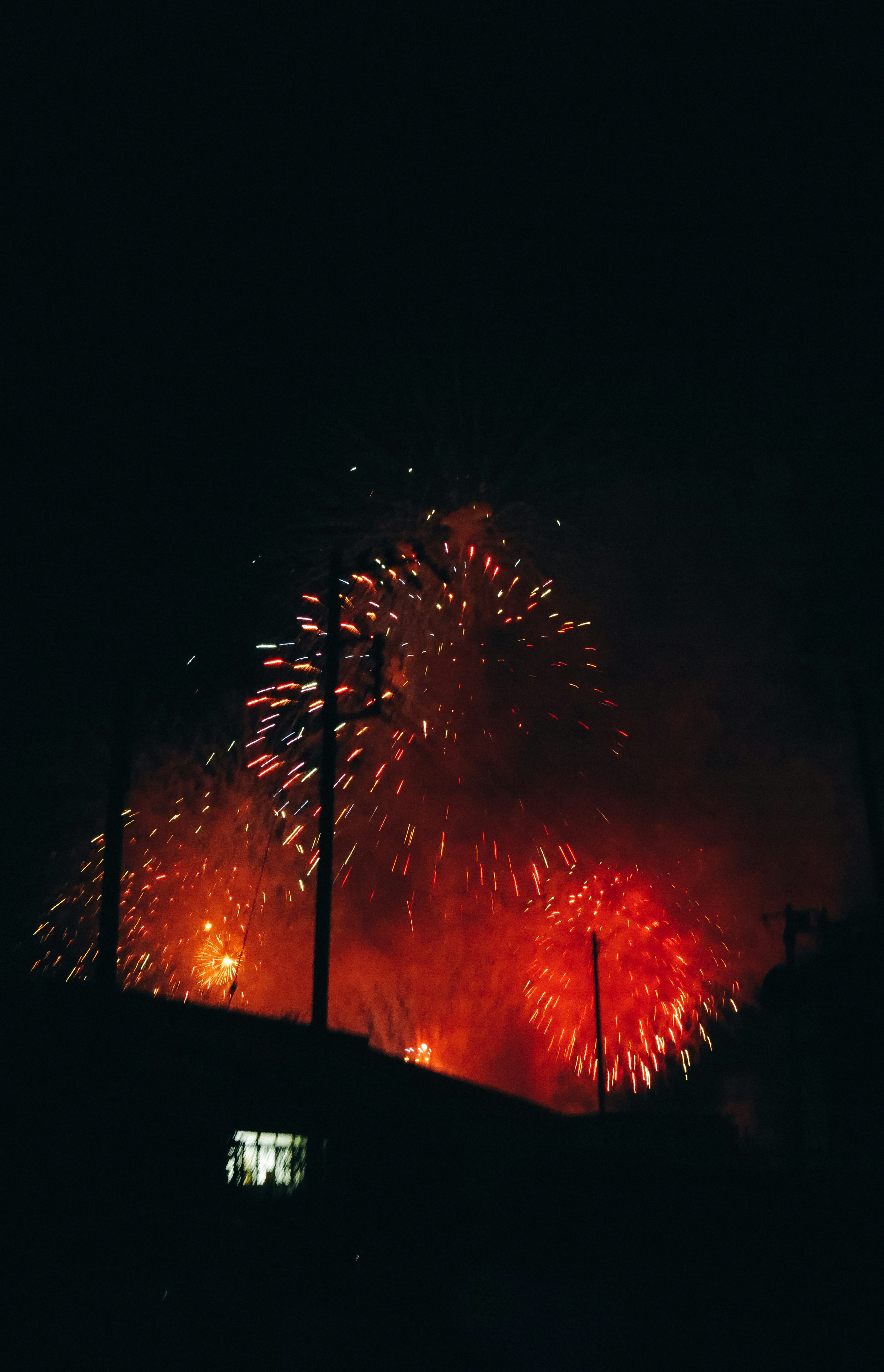 Spettacolare display di fuochi d'artificio rossi e arancioni che illuminano il cielo notturno