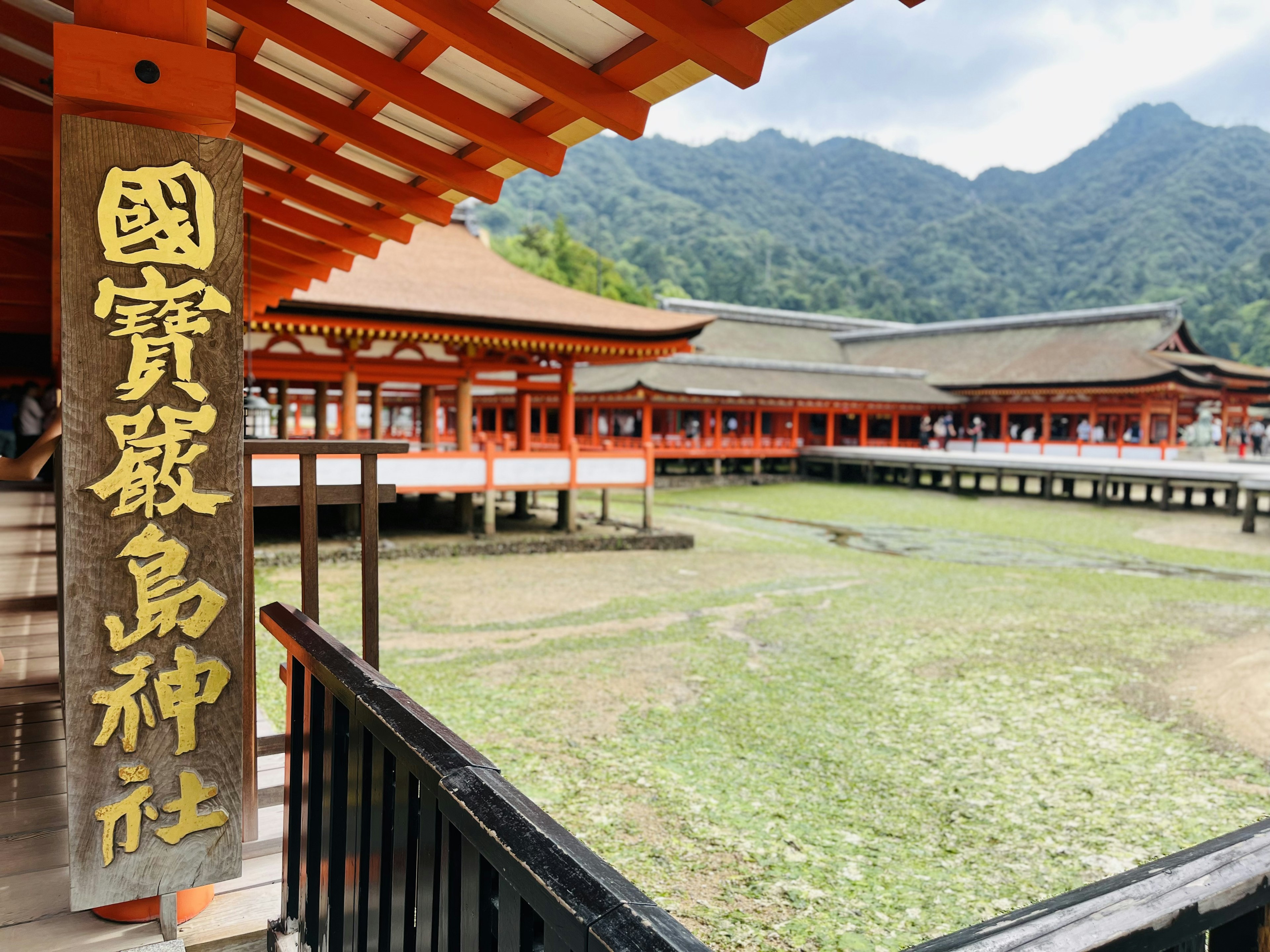 国宝の神社の赤い建物と山々の背景