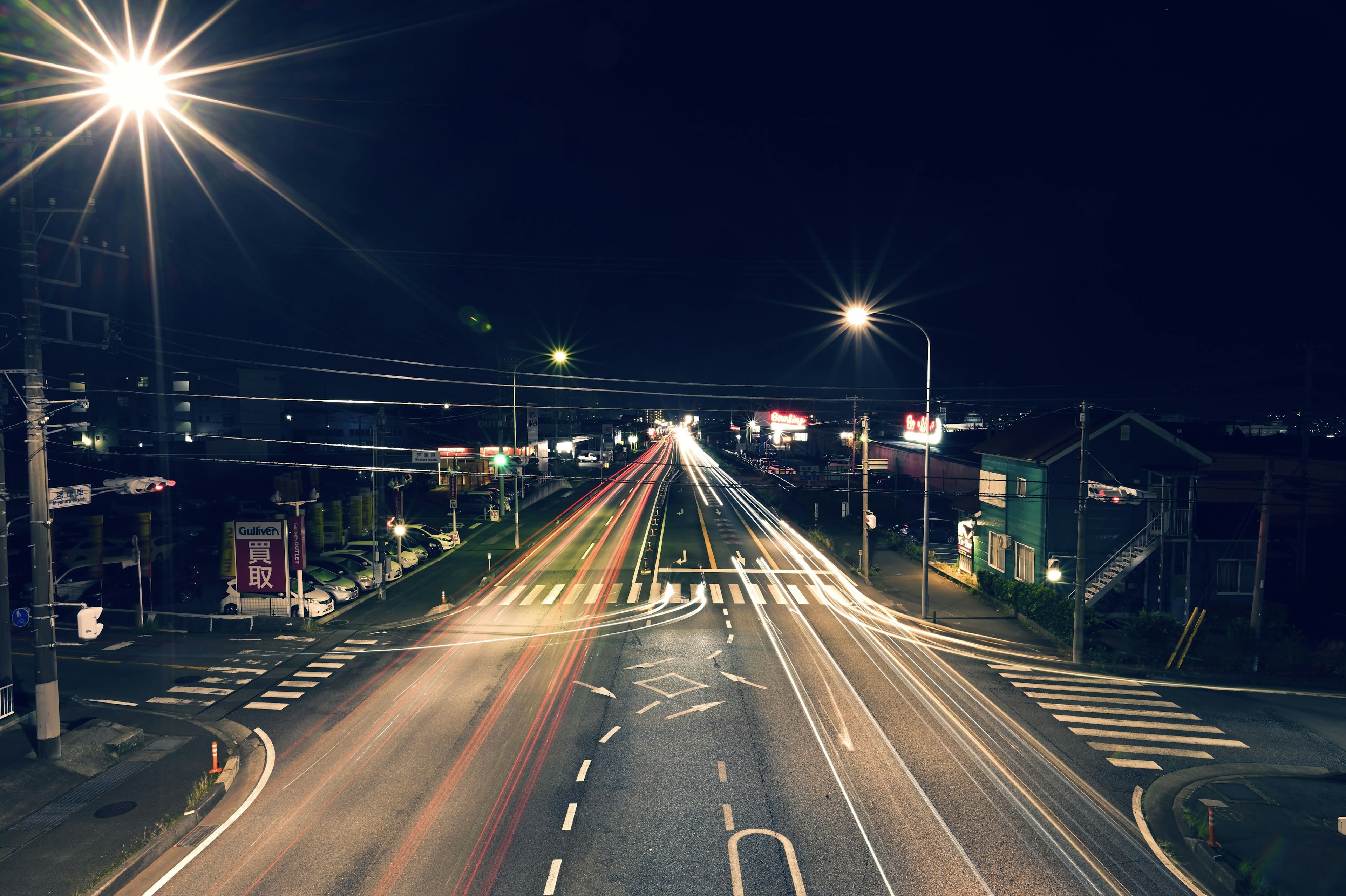 Light trails of cars on a road at night with streetlights