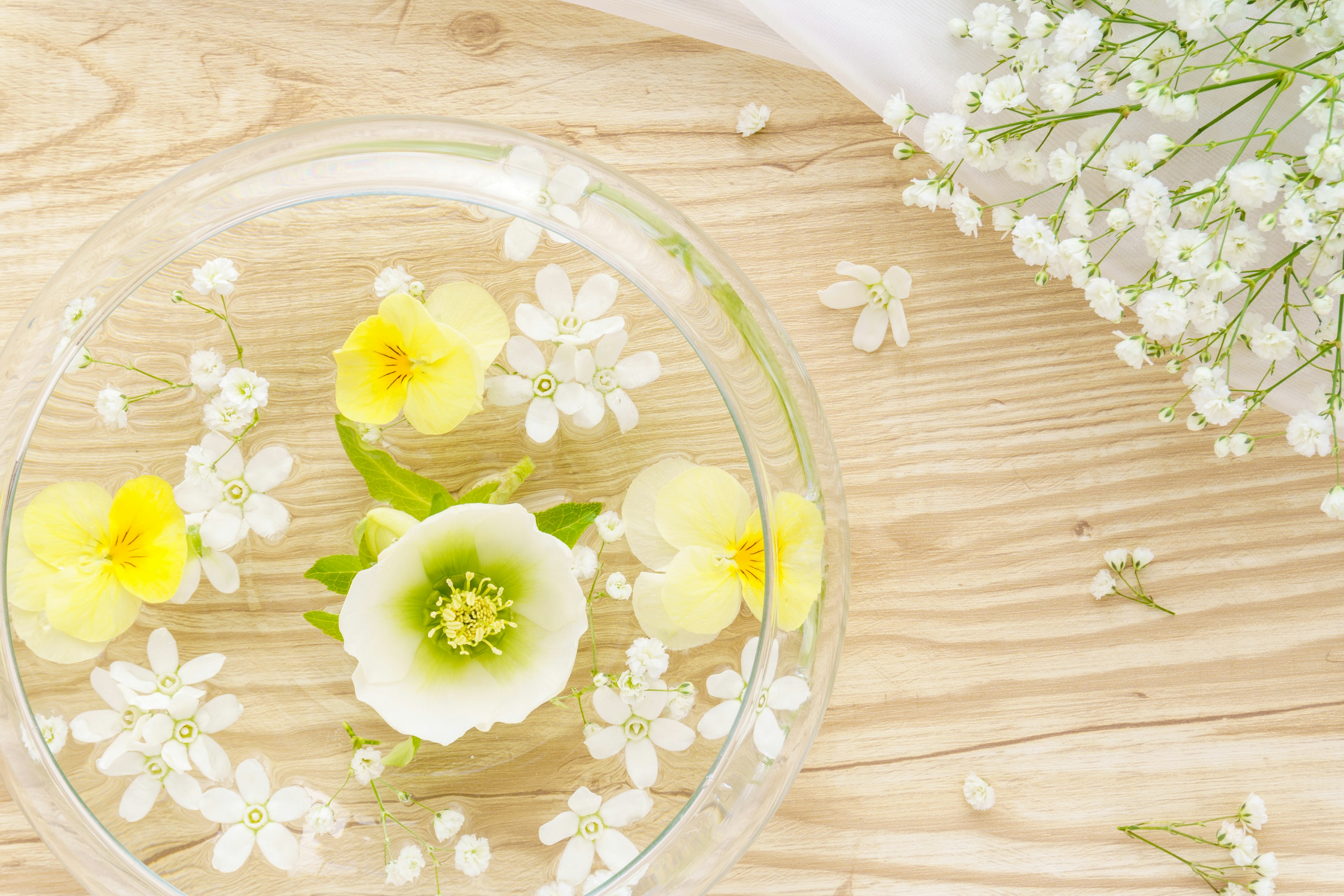 A beautiful arrangement of yellow flowers and white blossoms floating in water