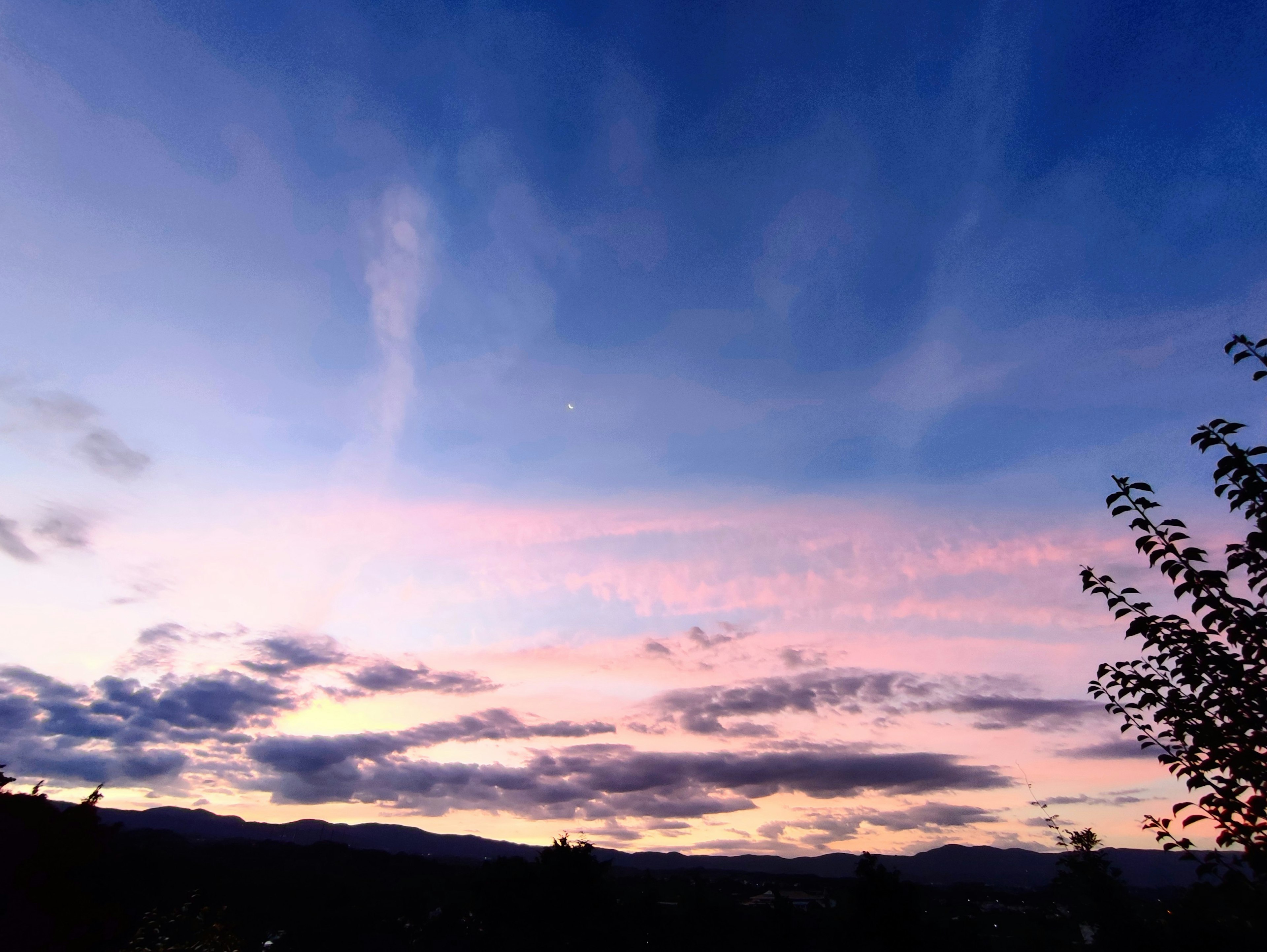 Langit senja dengan nuansa merah muda dan biru serta awan tersebar