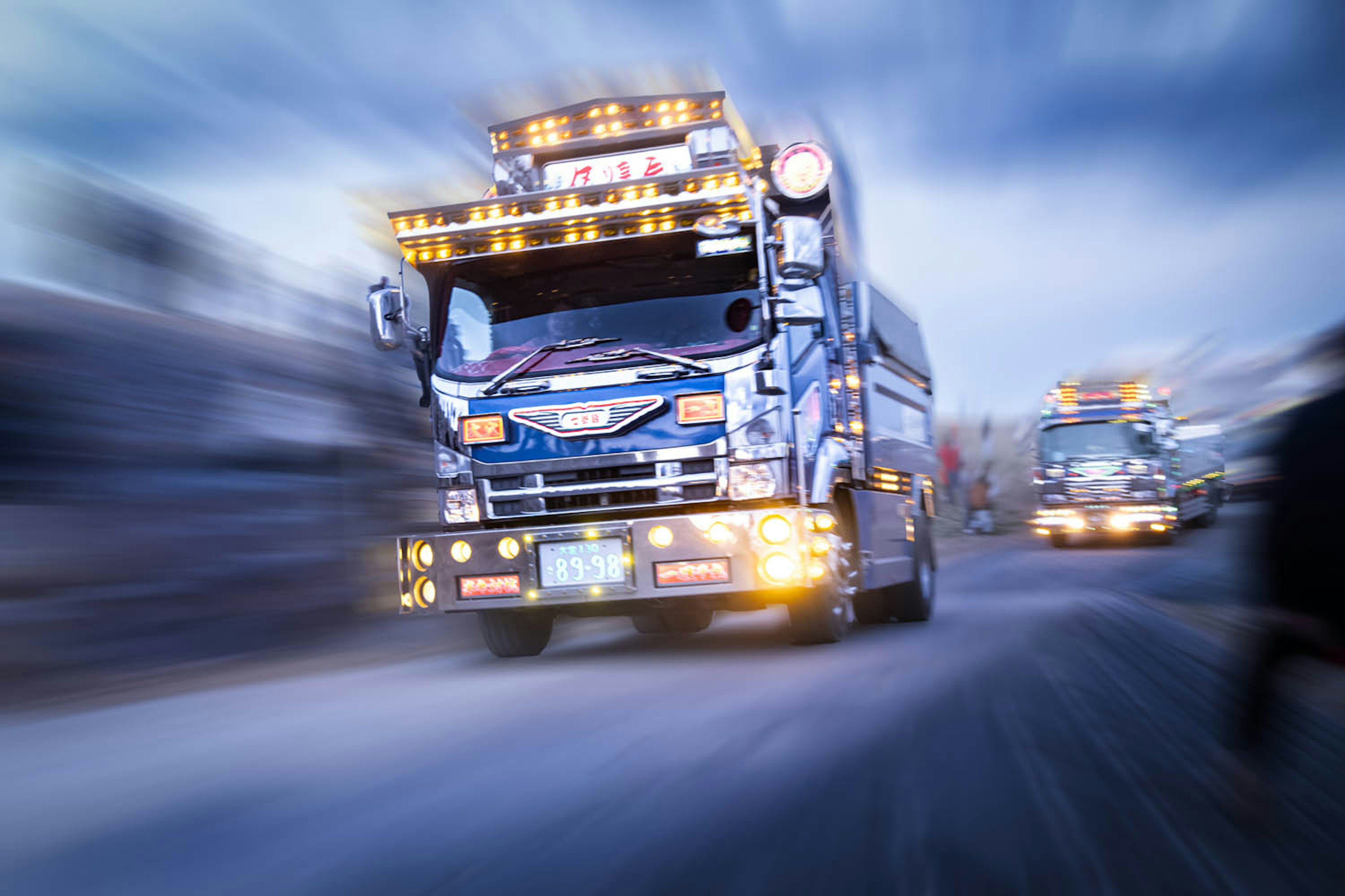 Dynamic scene of a truck in motion Blue truck adorned with bright lights