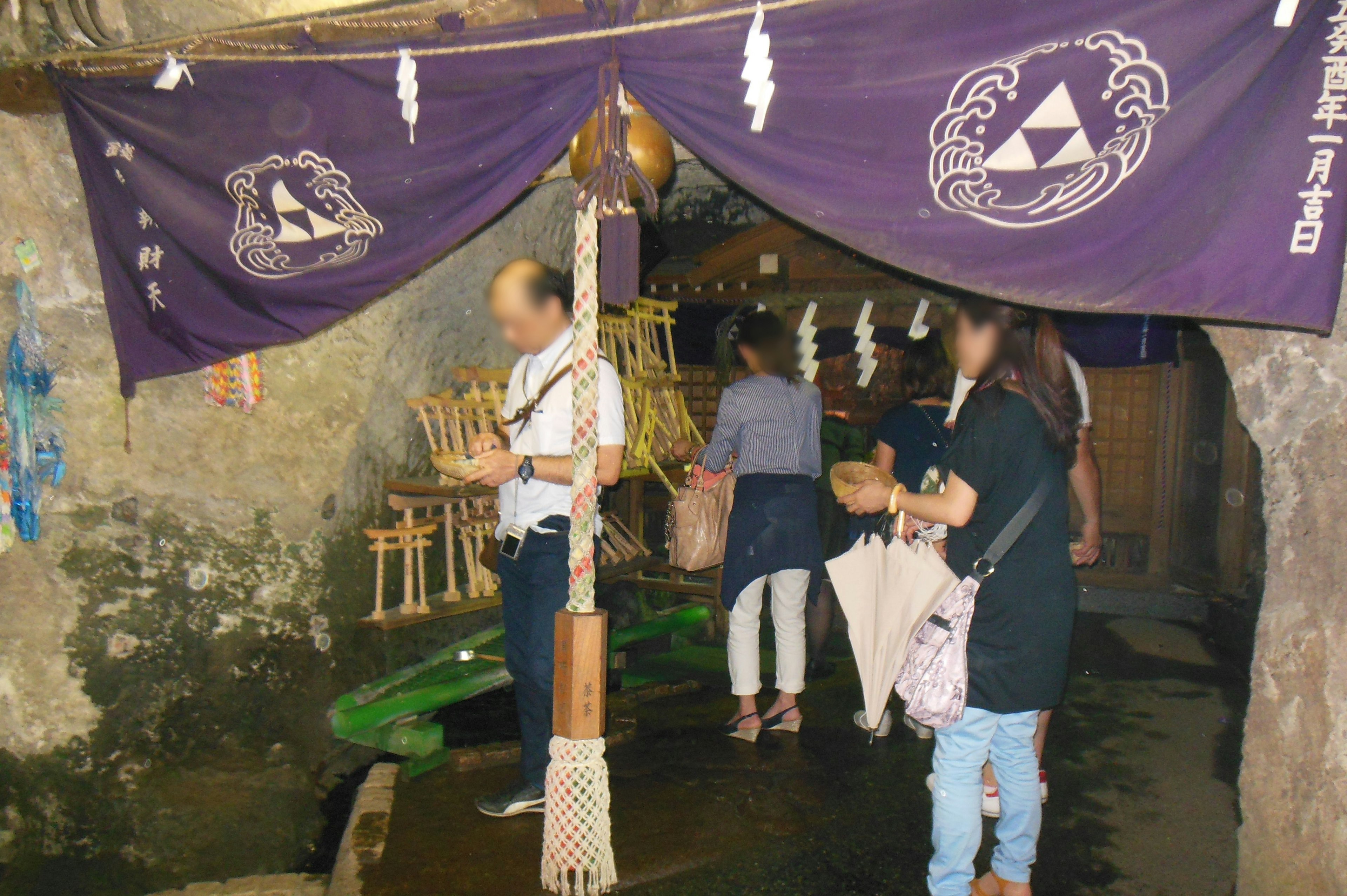 Interior de una cueva con visitantes y pancartas moradas